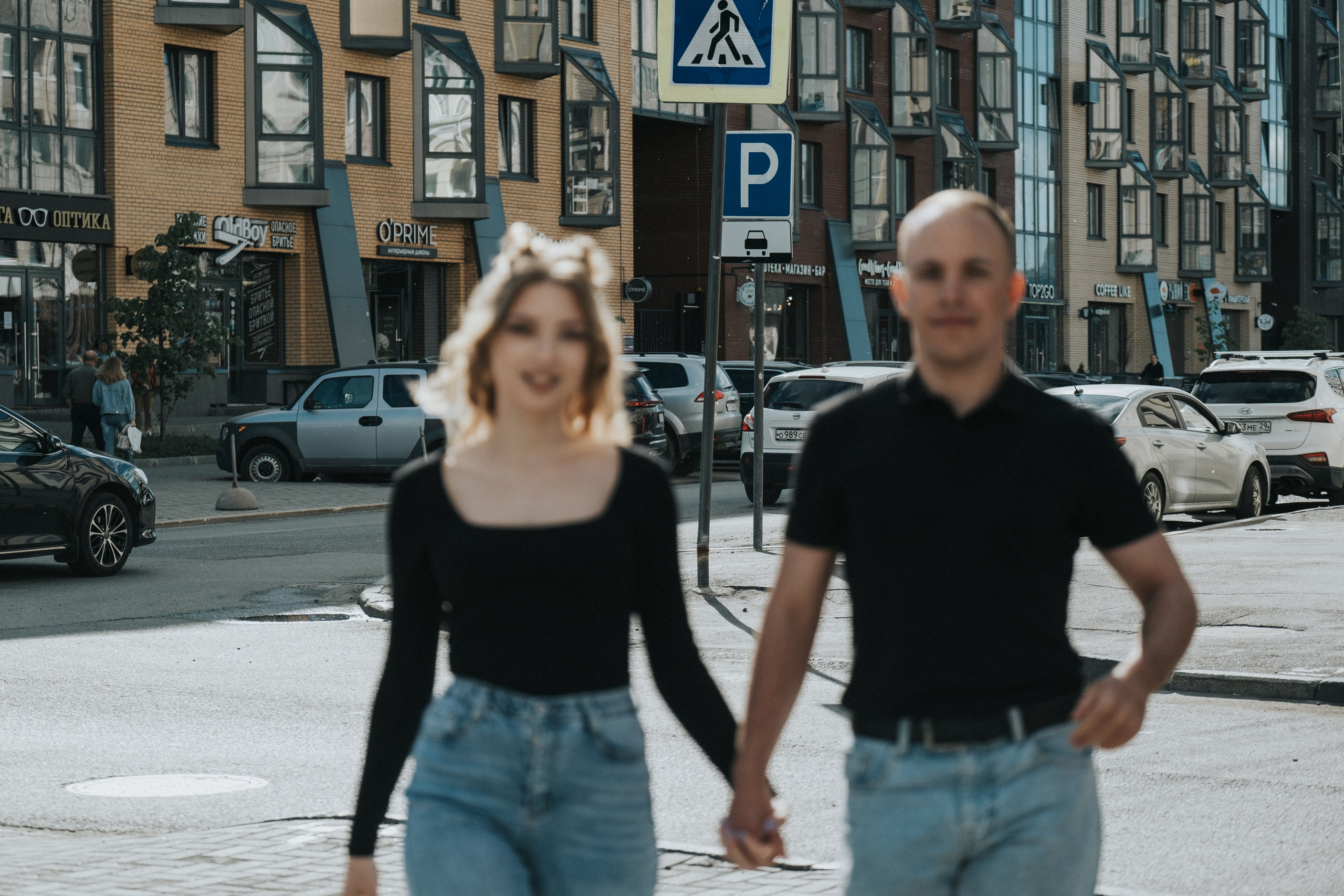 Молодая пара мужчина и девушка гуляют по городу Архангельску держась за руки в черных футболках и синих джинсах, лав стори для влюбленной пары на кануне свадьбы. 