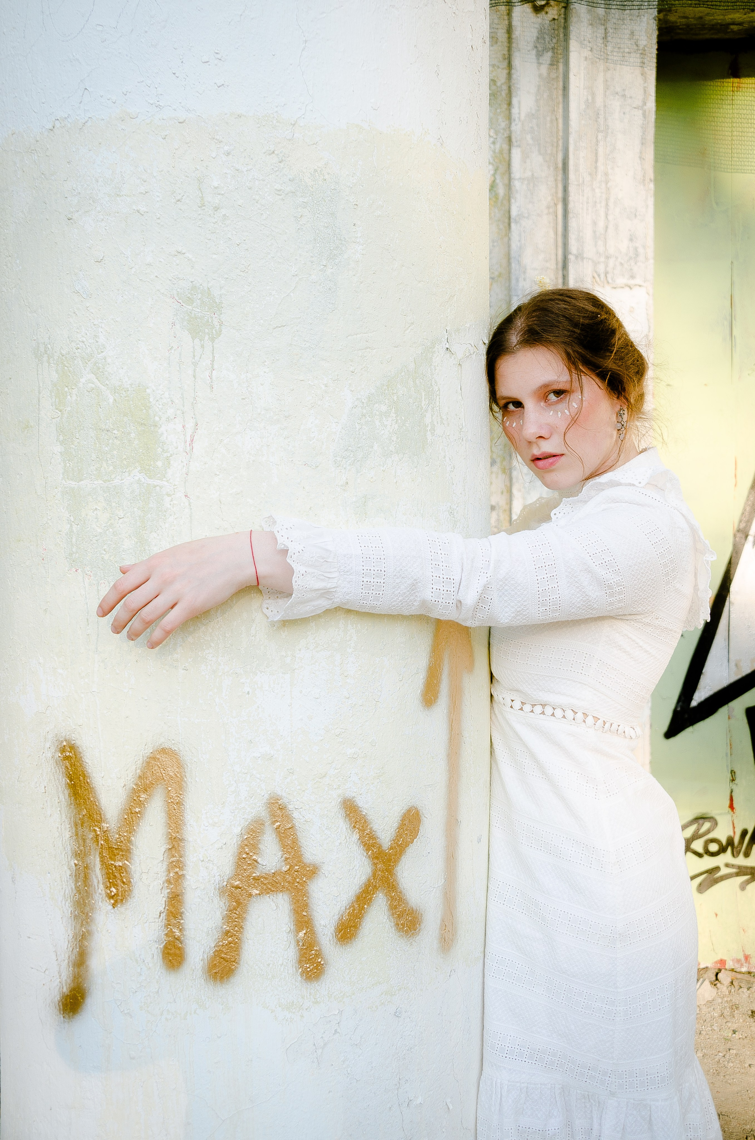 старый заброшенный советский кинотеатр и девшка в нем обнимает колонну.