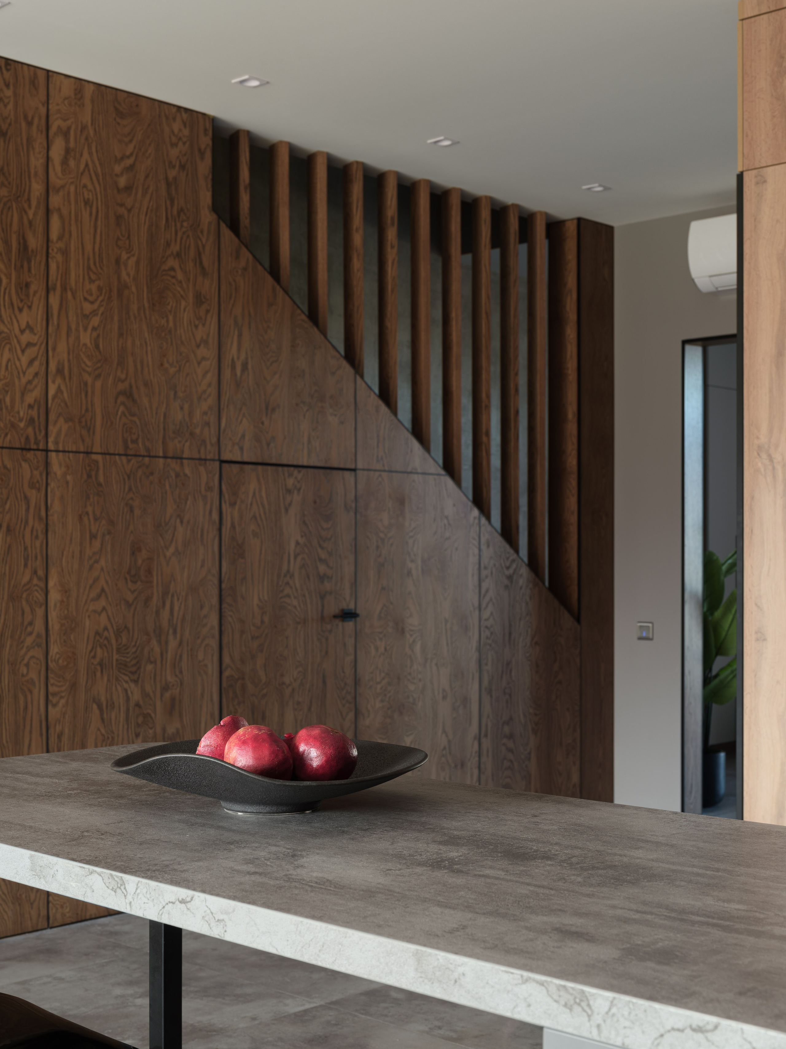 Интерьер кухни с акцентом на фактурное дерево и графитовые поверхности, вид на лестницу и декоративные рейки. Тепло дерева и строгость линий — работа дизайнера Алины Дёровой, стилиста Натальи Якушевой, фотографа Сергея Денисенко.