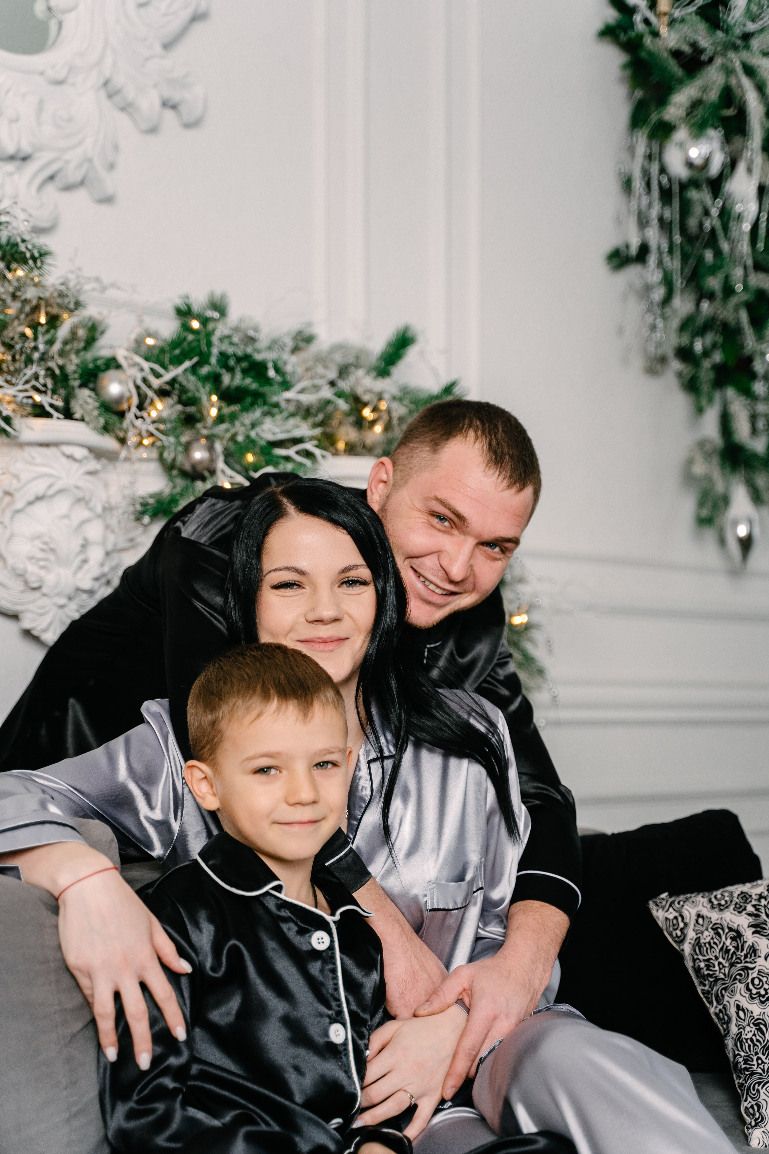 семейная пара с ребенком сидят на диване в канун Нового года