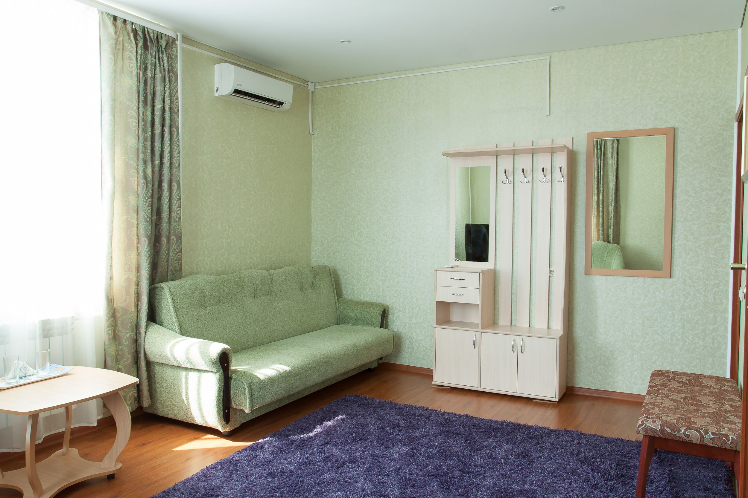 Гостевой дом Горница в Вологде, интерьерная съемка гостиной зоны с диваном и креслом.