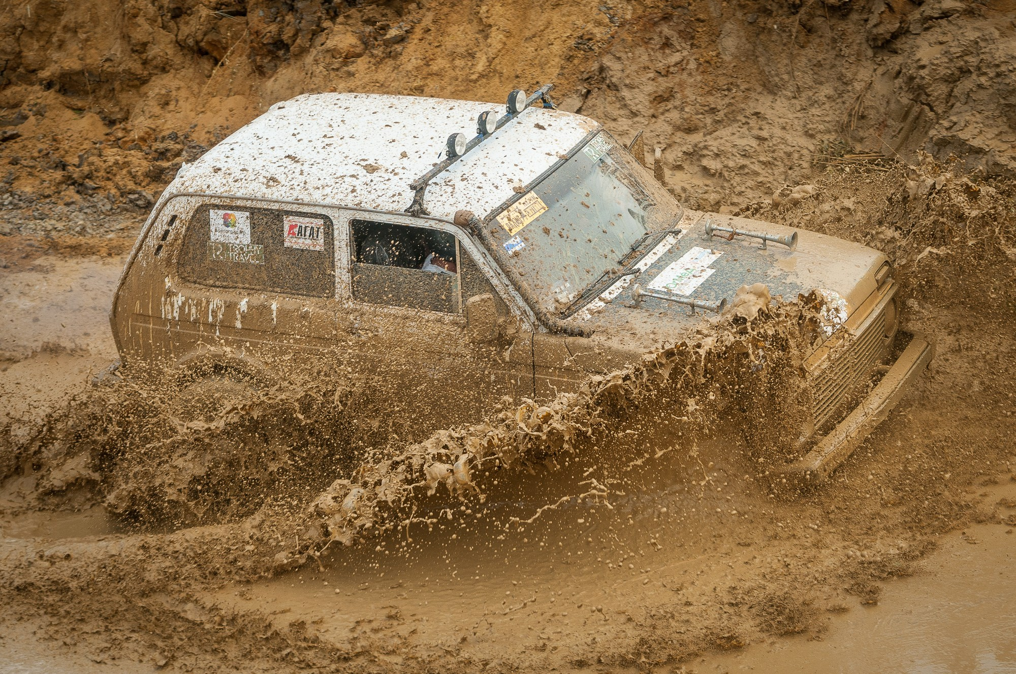 Автомобиль на скорости поднимает брызги грязи, разлетающиеся в стороны