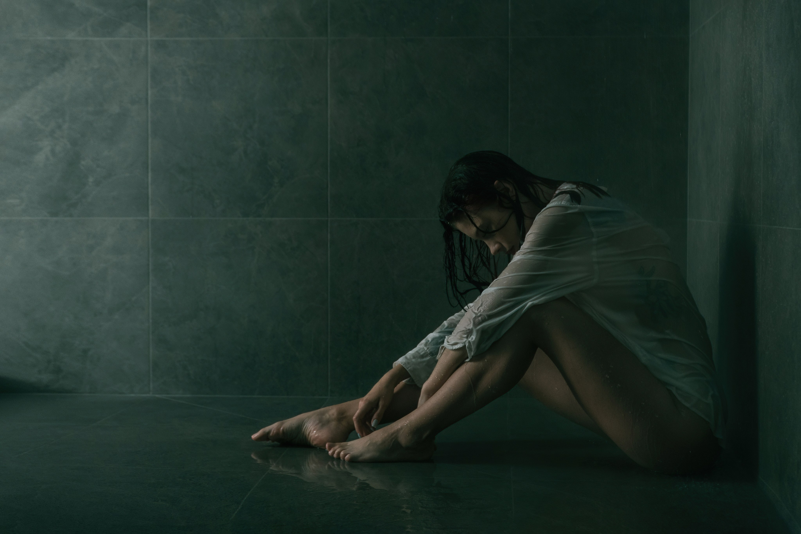Отчаяние, глубокое горе, расстройство. Девушка сидит на полу в душе.