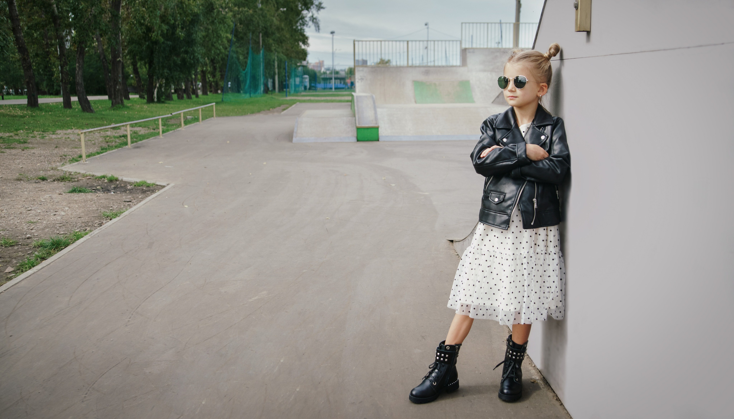 Детская фотосессия летом - девочка стоя в кожаной куртке