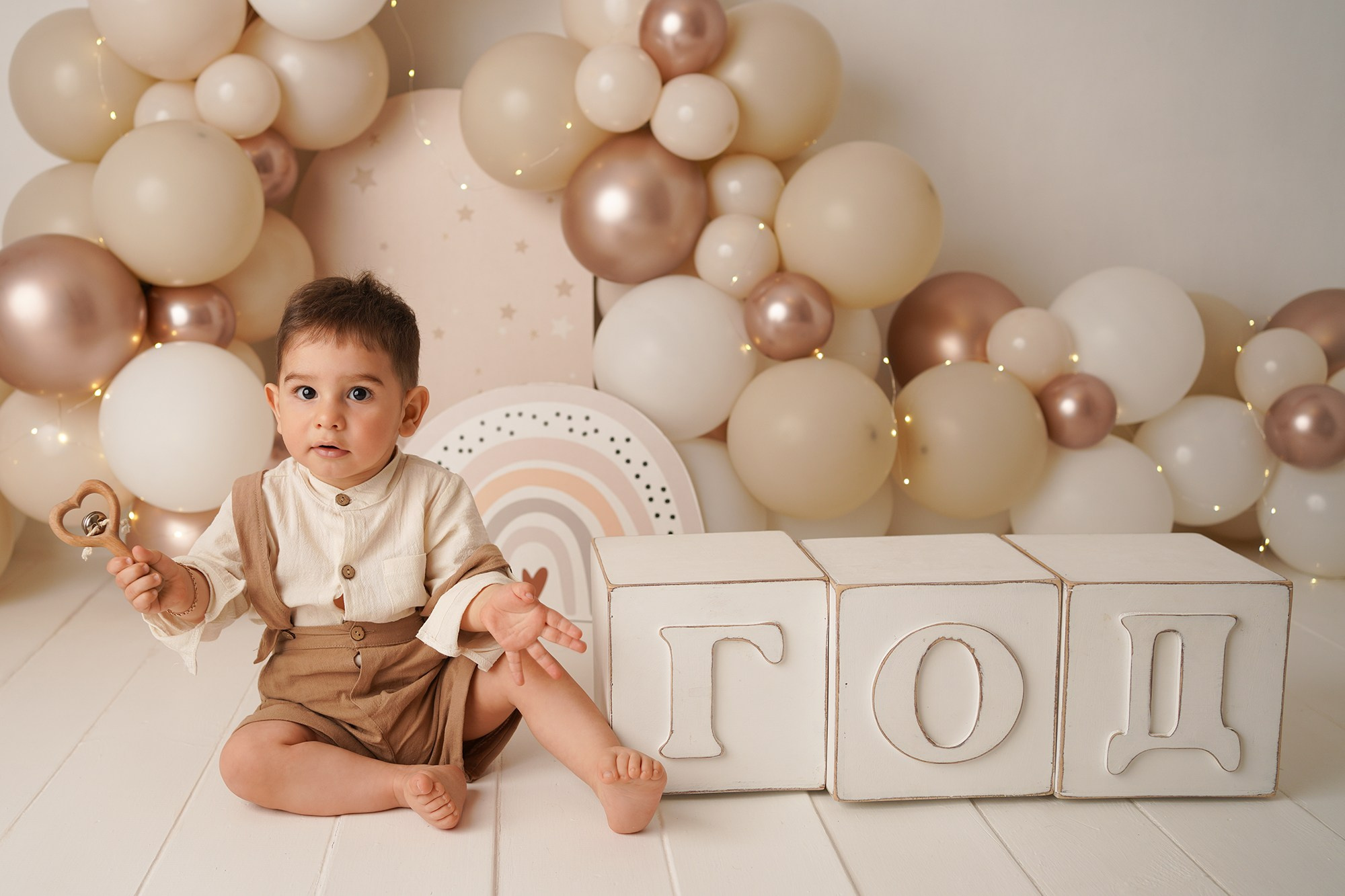 Малыш сидит на полу рядом с кубиками год, потому что сегодня его первый день рождения.