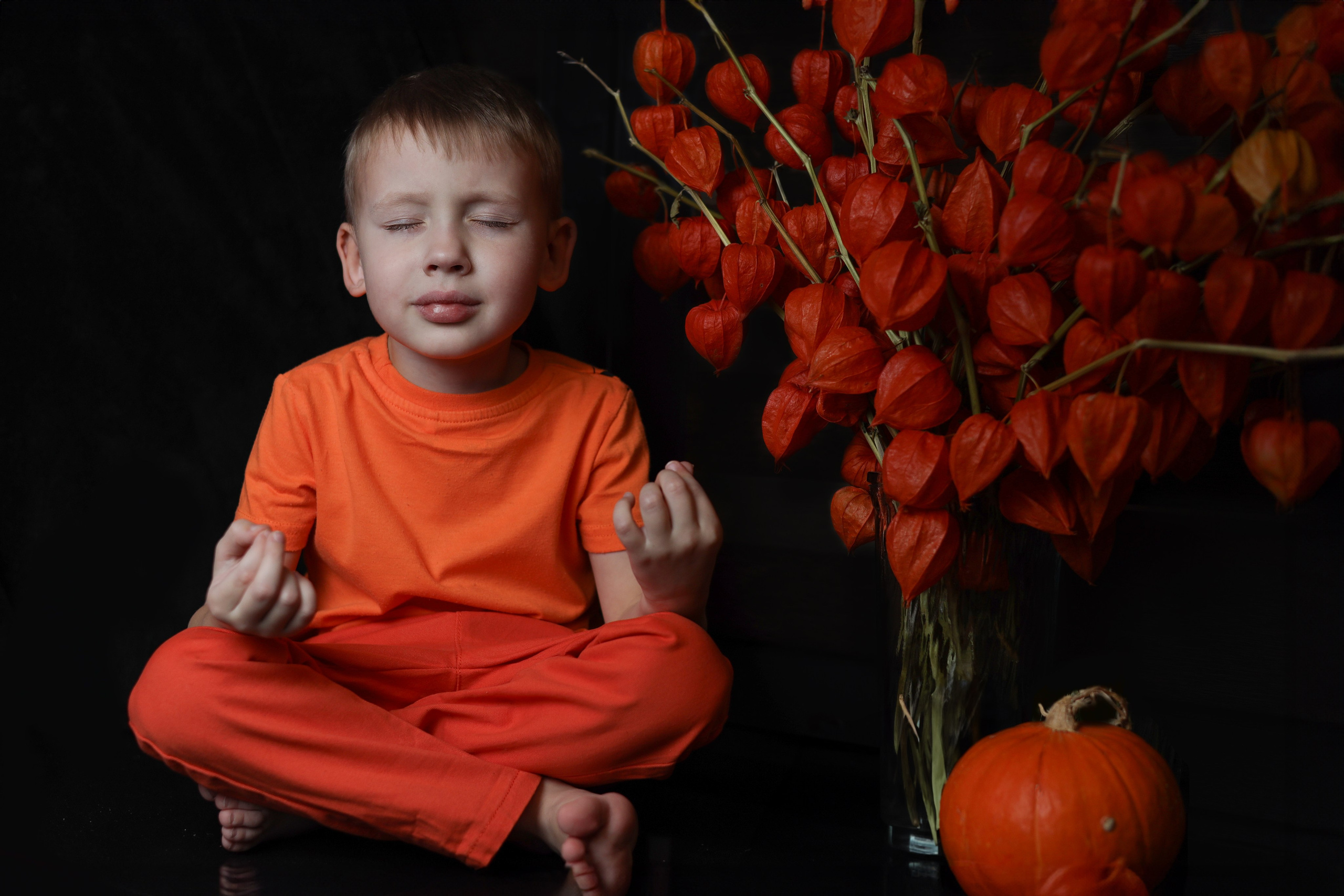 фотосессия в студии с ребенком в оранжевой одежде с физалисами