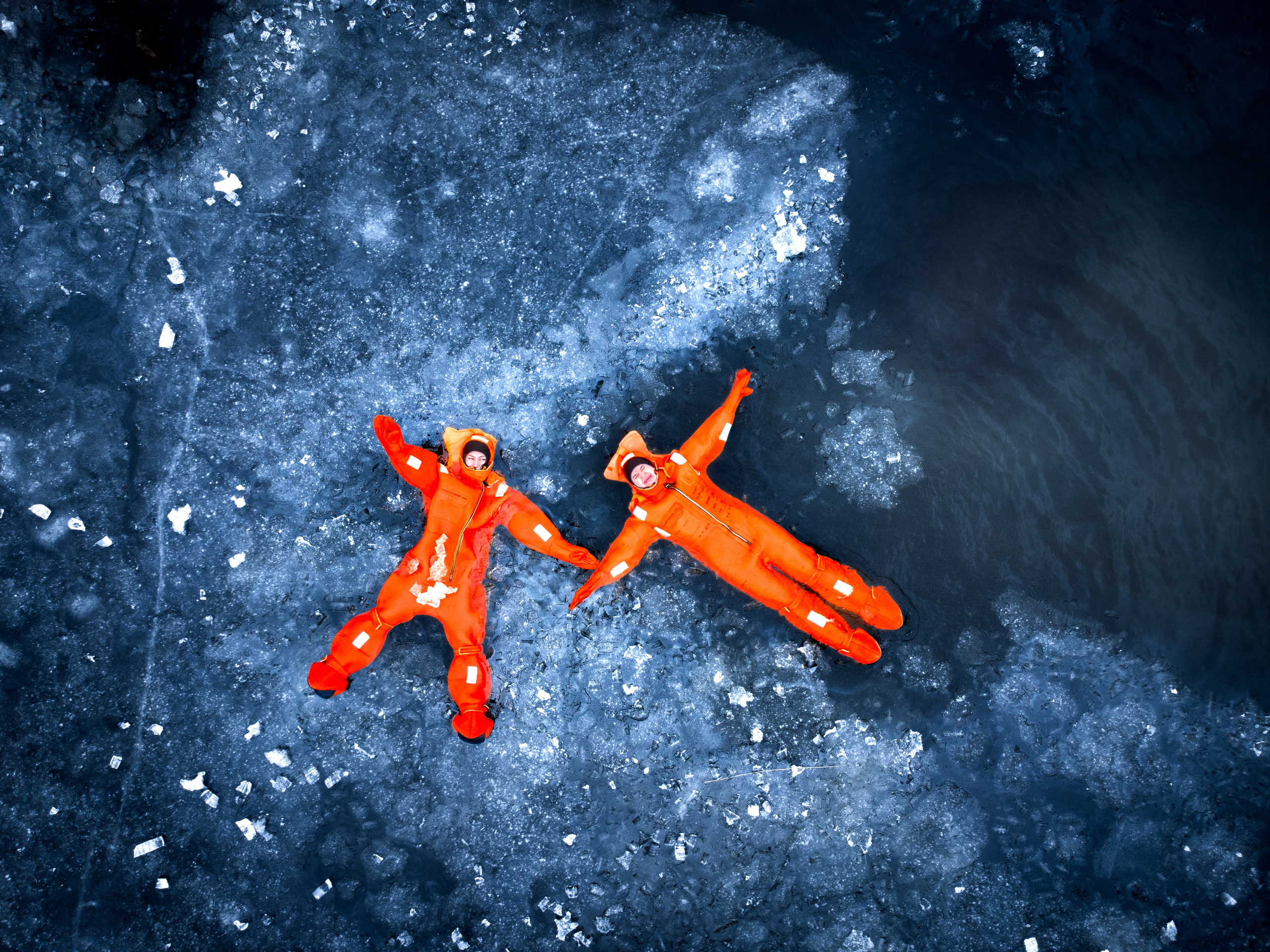 Люди купаются среди льдин, в спасательных оранжевых термо костюмах, айс флоатинг Ярославль