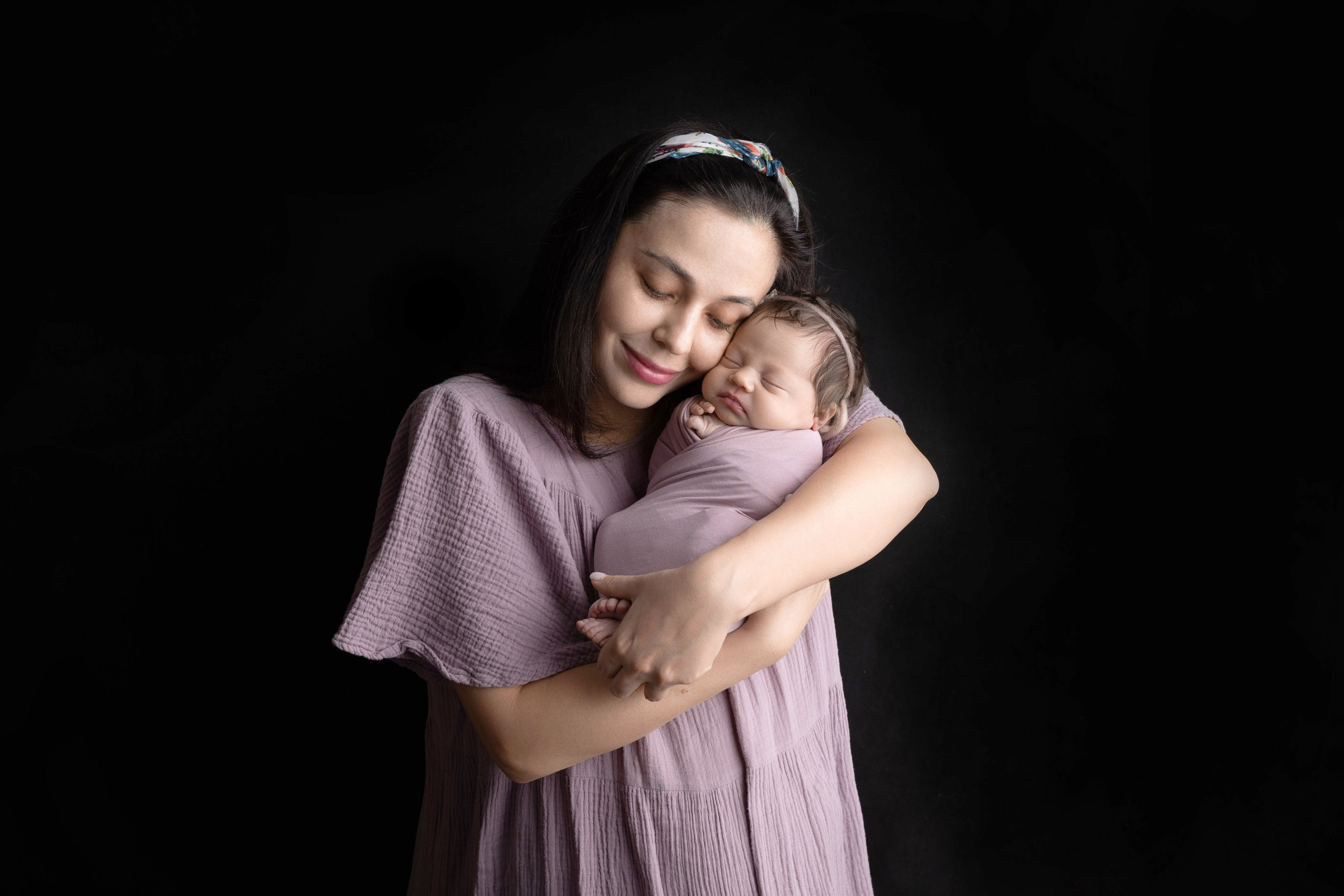 Мама прижимает к себе новорожденную девочку