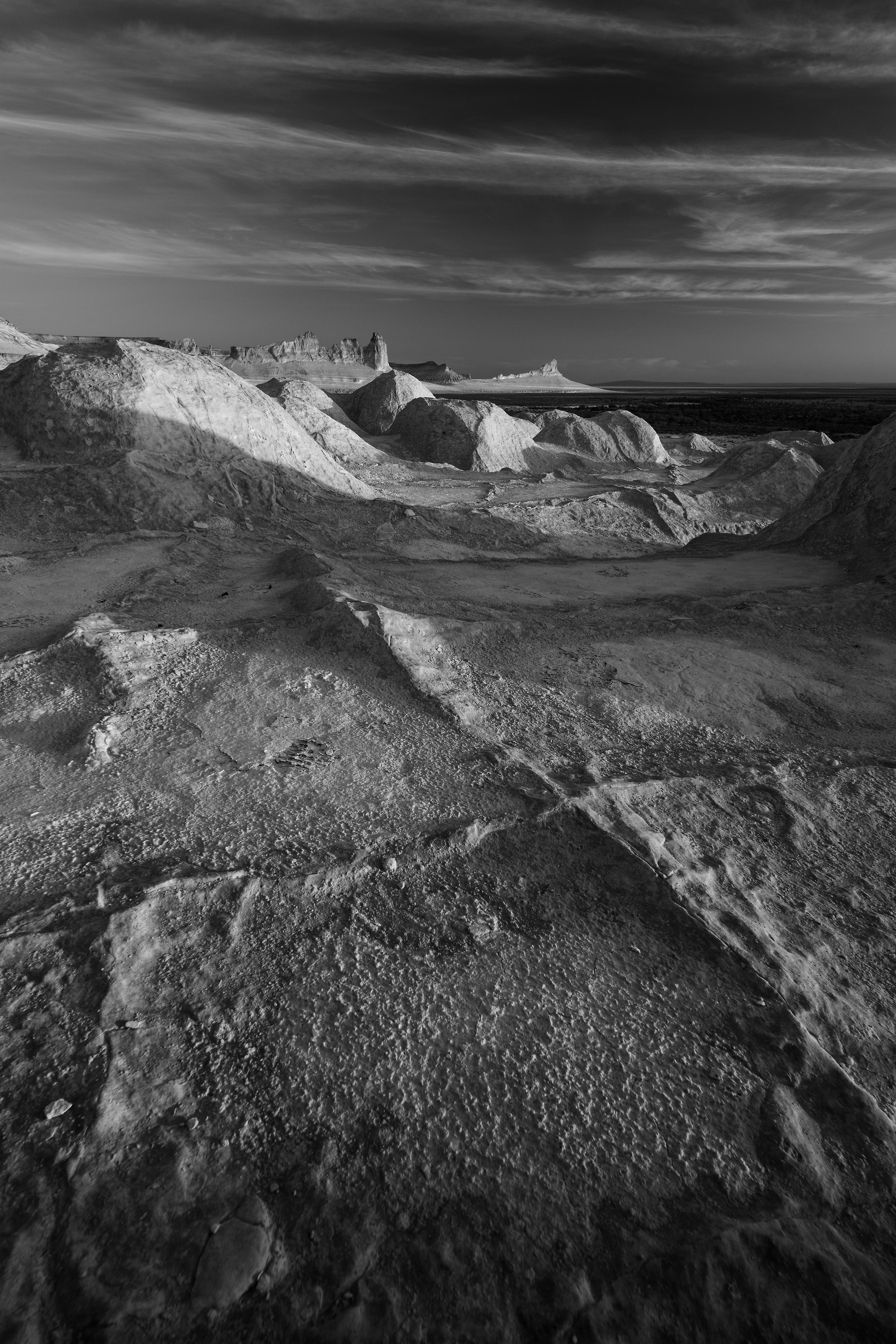 Трещины на переднем плане и Бозжира на заднем на закате