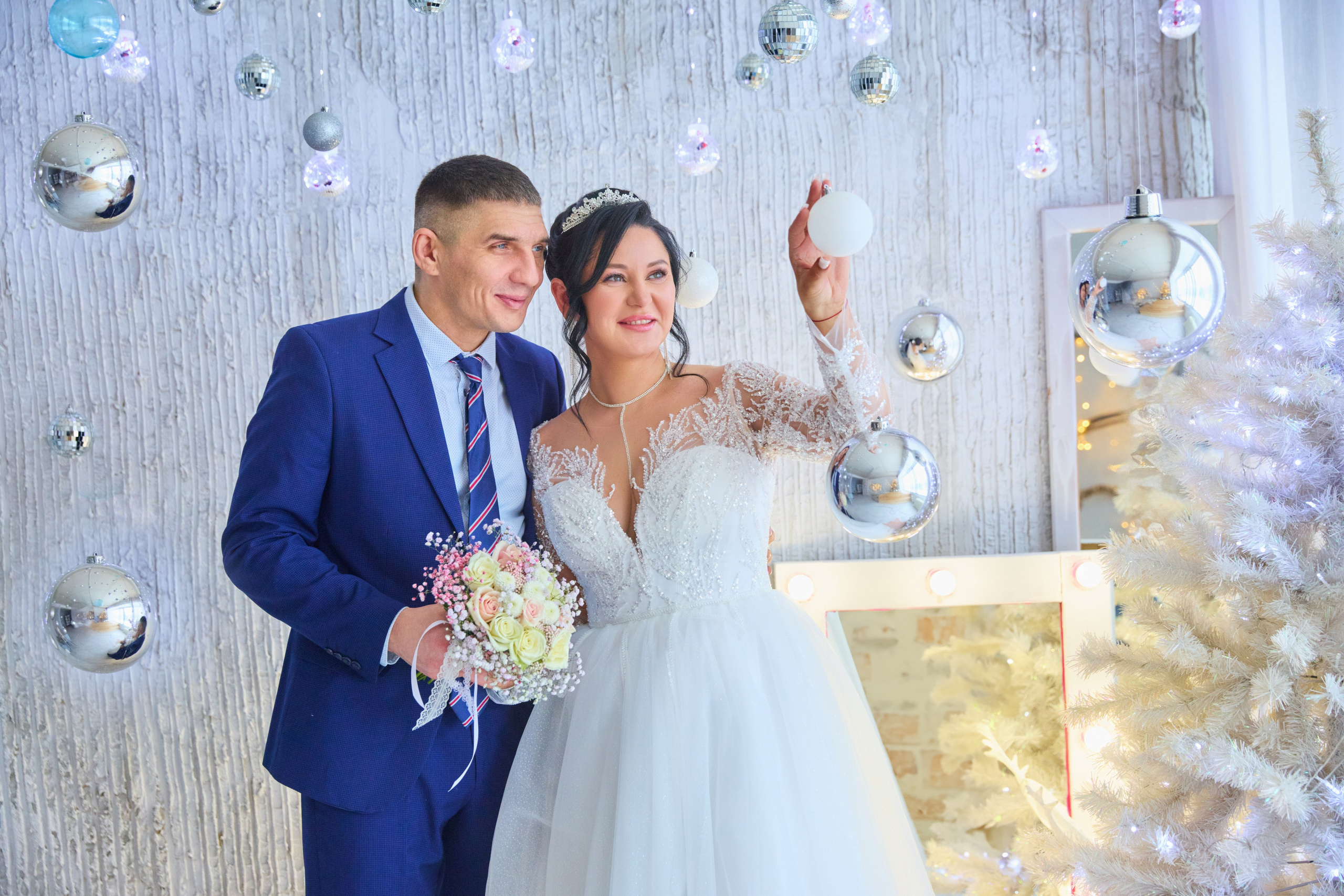 невеста трогаем елочную игрушку, жених взади