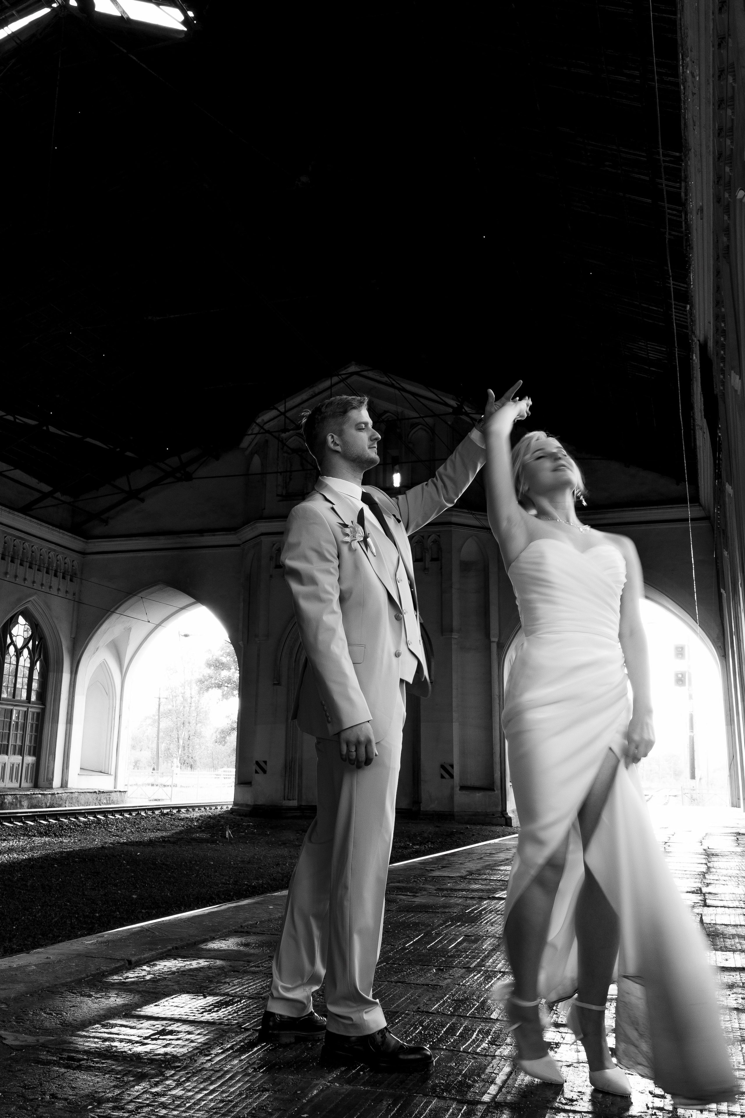Свадьба в Санкт-Петербурге, фотосессия на прогулке, жених кружит невесту под рукой на вокзале.