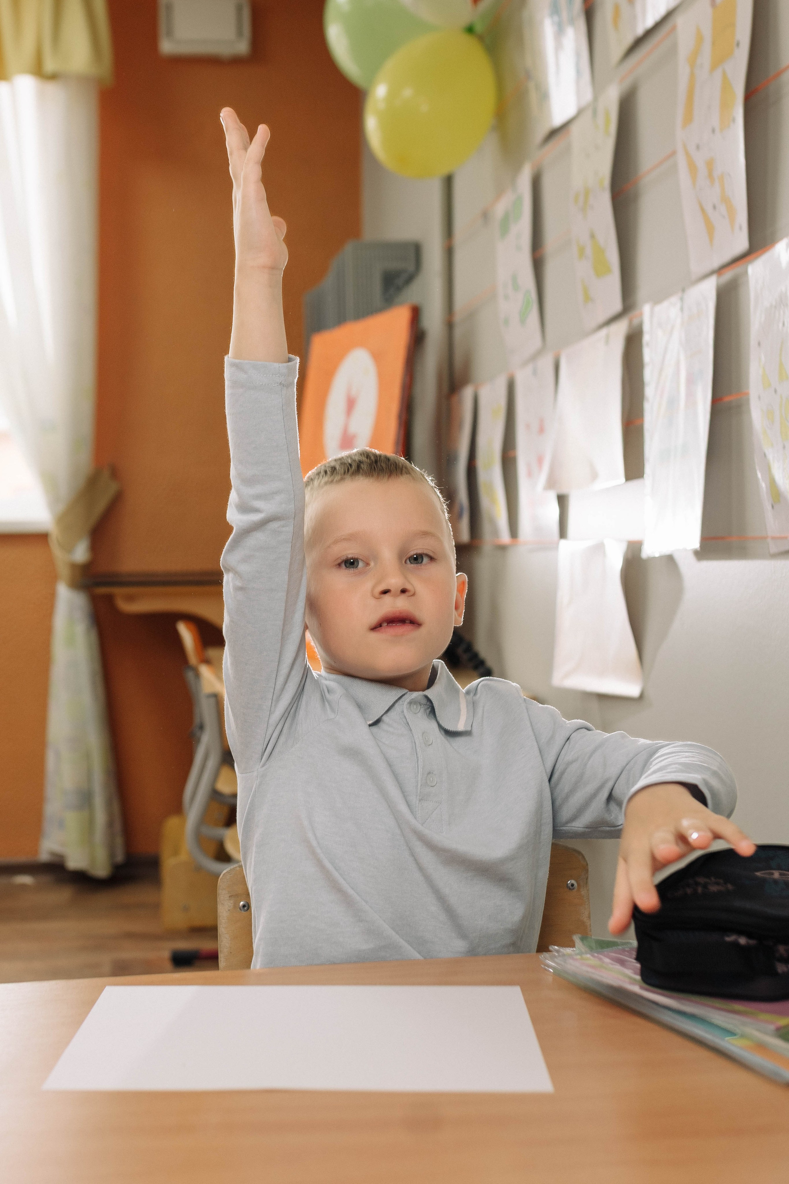 Мальчик тянет руку на уроке