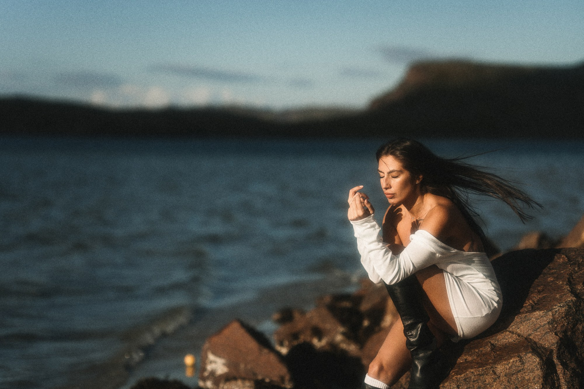 Женский портрет на берегу Баренцева моря, в Териберке. Ветер развевает волосы, светит закатное солнце,