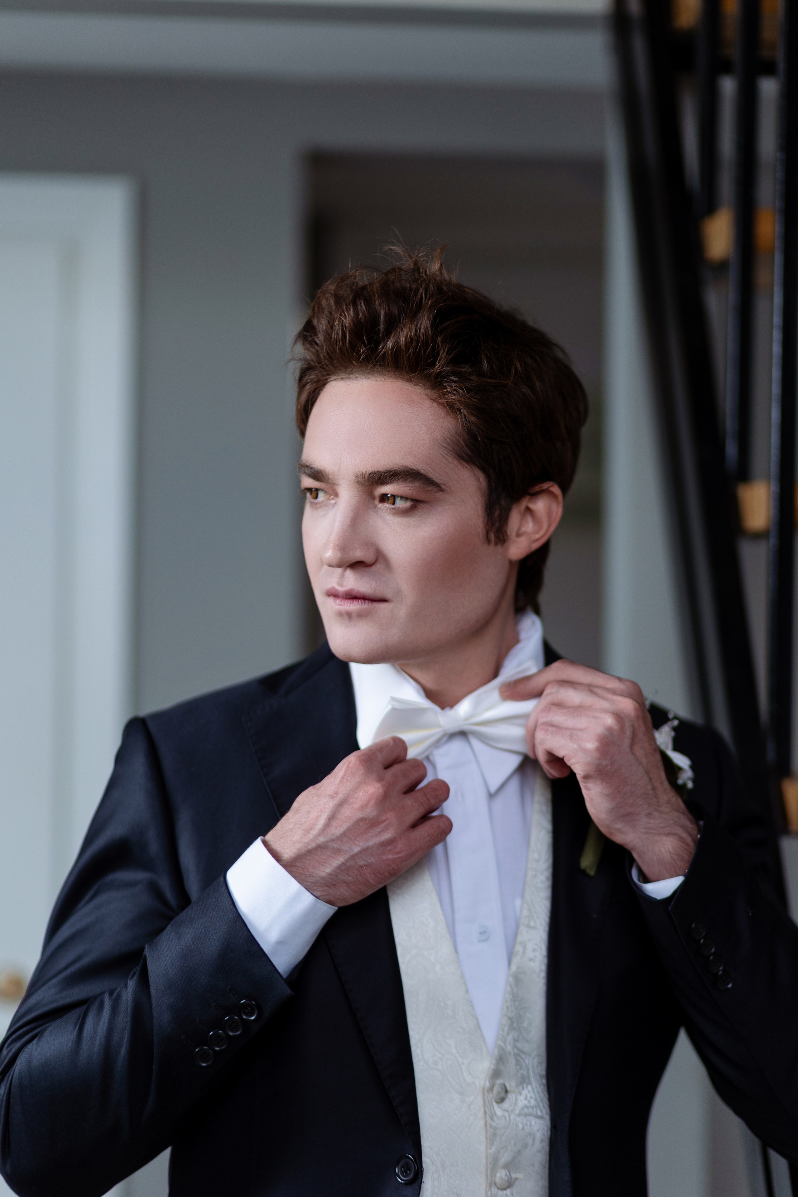 Жених поправляет свою белоснежную бабочку.