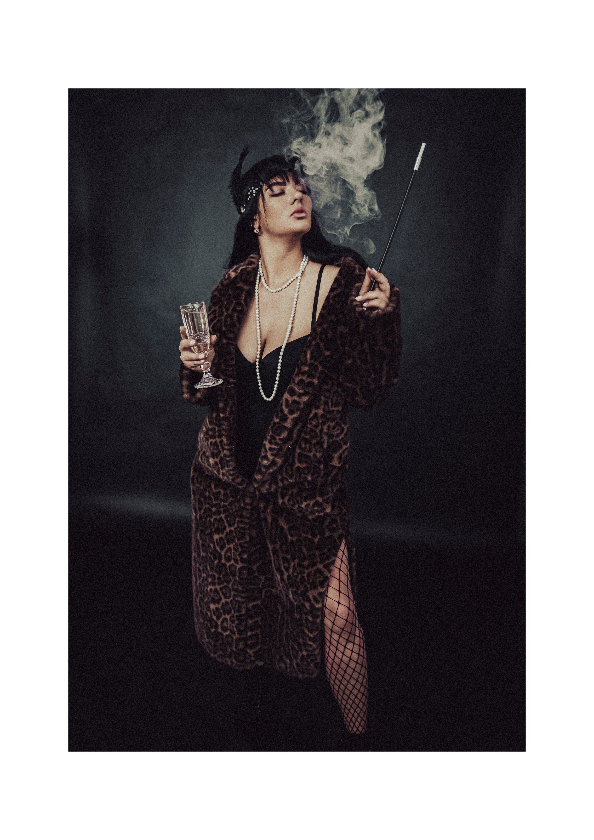 Женщина в леопардовой шубе, черном платье и черных сетчатых колготках держит бокал шампанского и длинный мундштук с дымом, стиль 1920-х годов, винтажный образ на темном фоне.