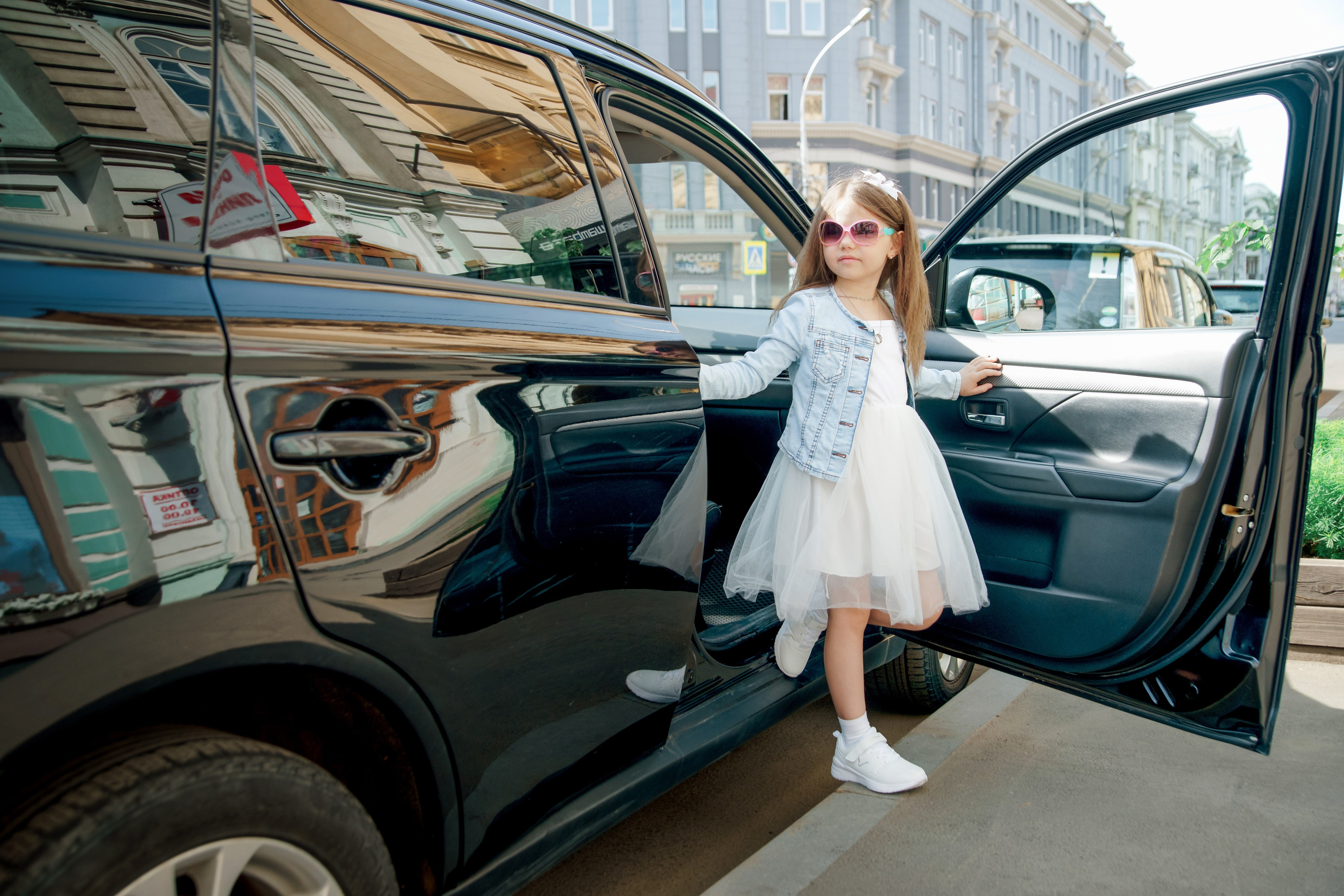 Детская фотосессия летом - девочка выходит из автомобиля