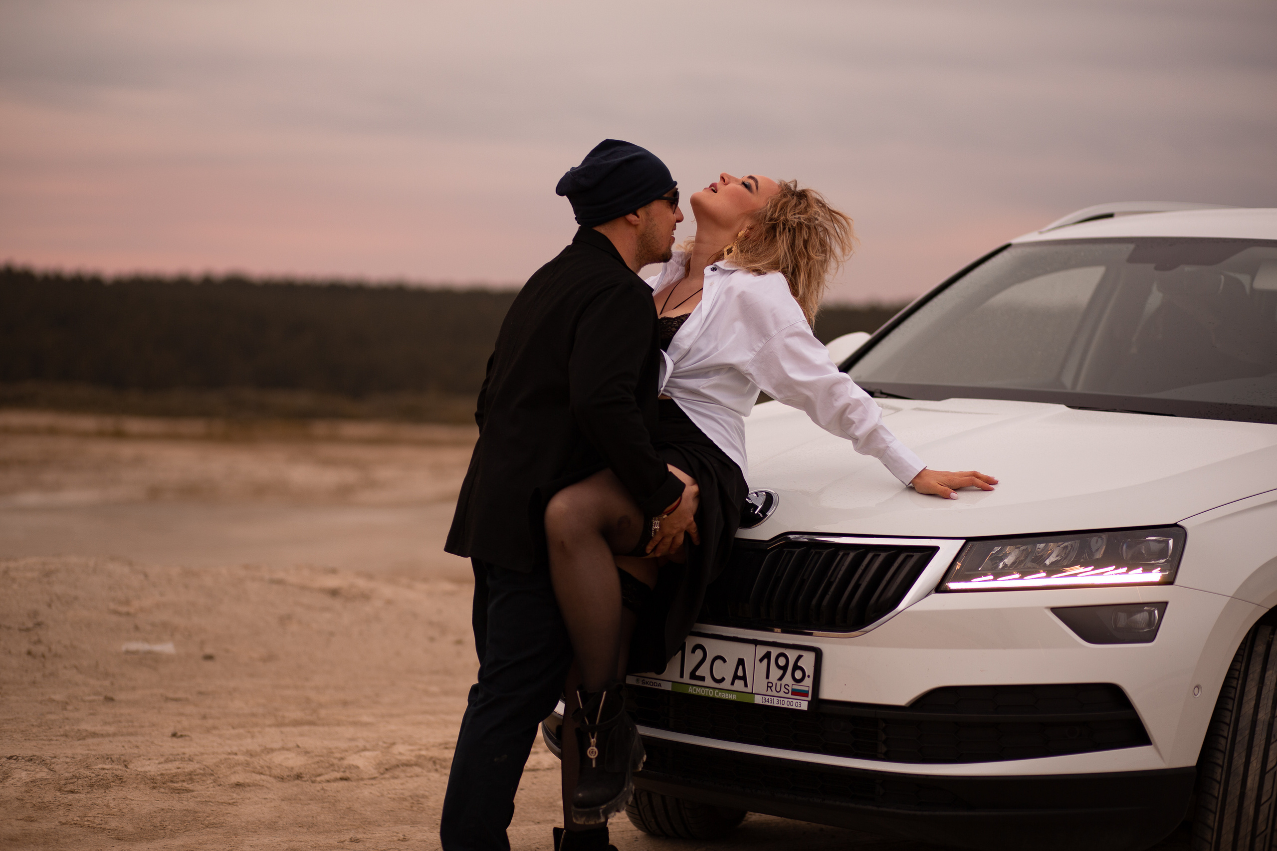 пара на капоте белой машины целуются