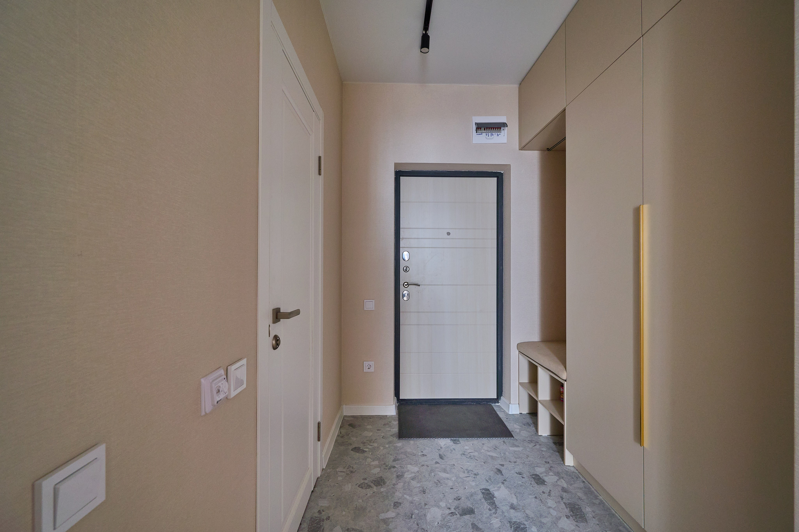 коридор с белой входной дверью бежевыми обоями 