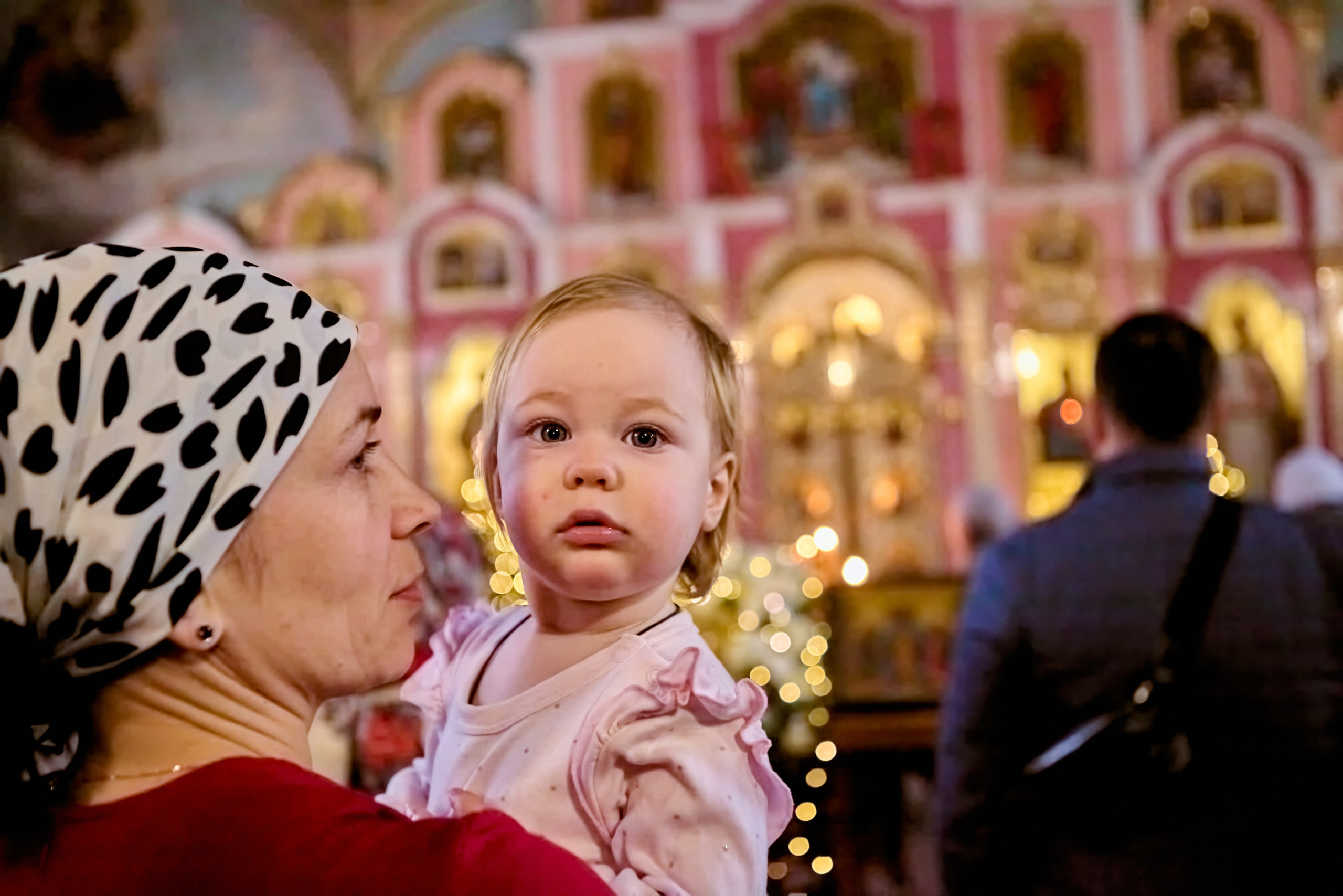 Мама с дочкой на руках на Новогодней службе