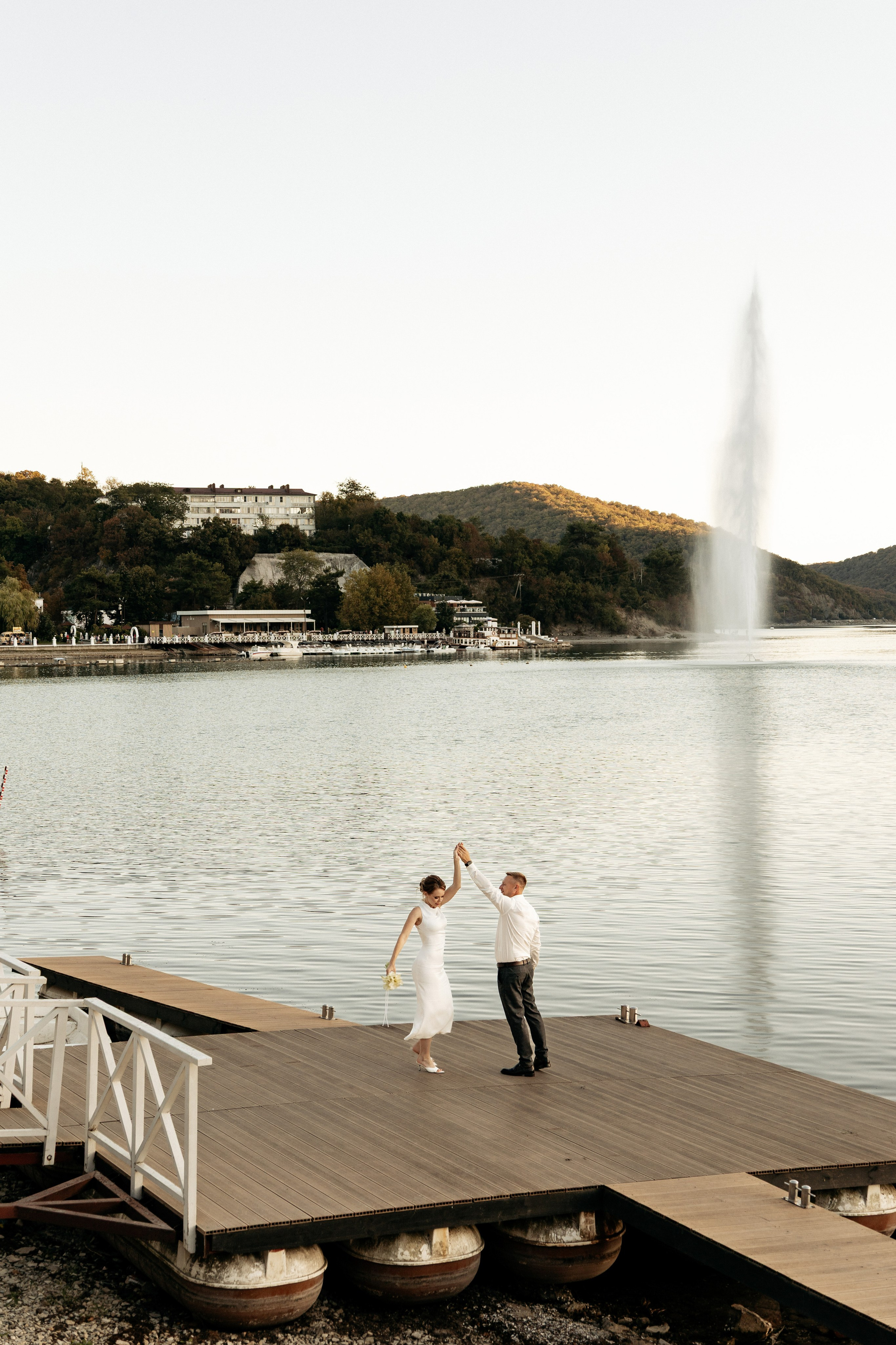  Жених кружит невесту на руках на берегу озера