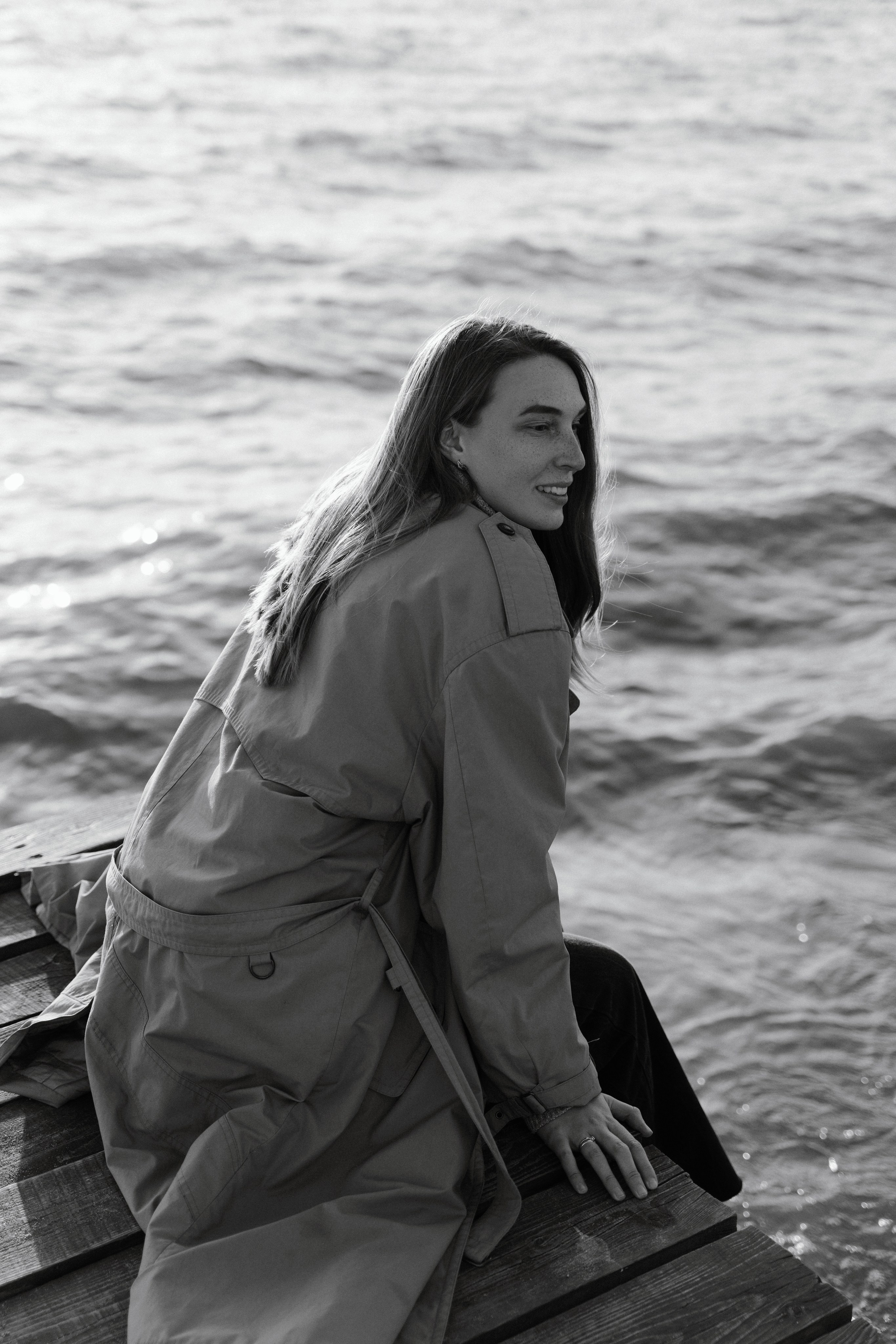 Фото девушки в плаще со спины на пристани на пляже Оби 