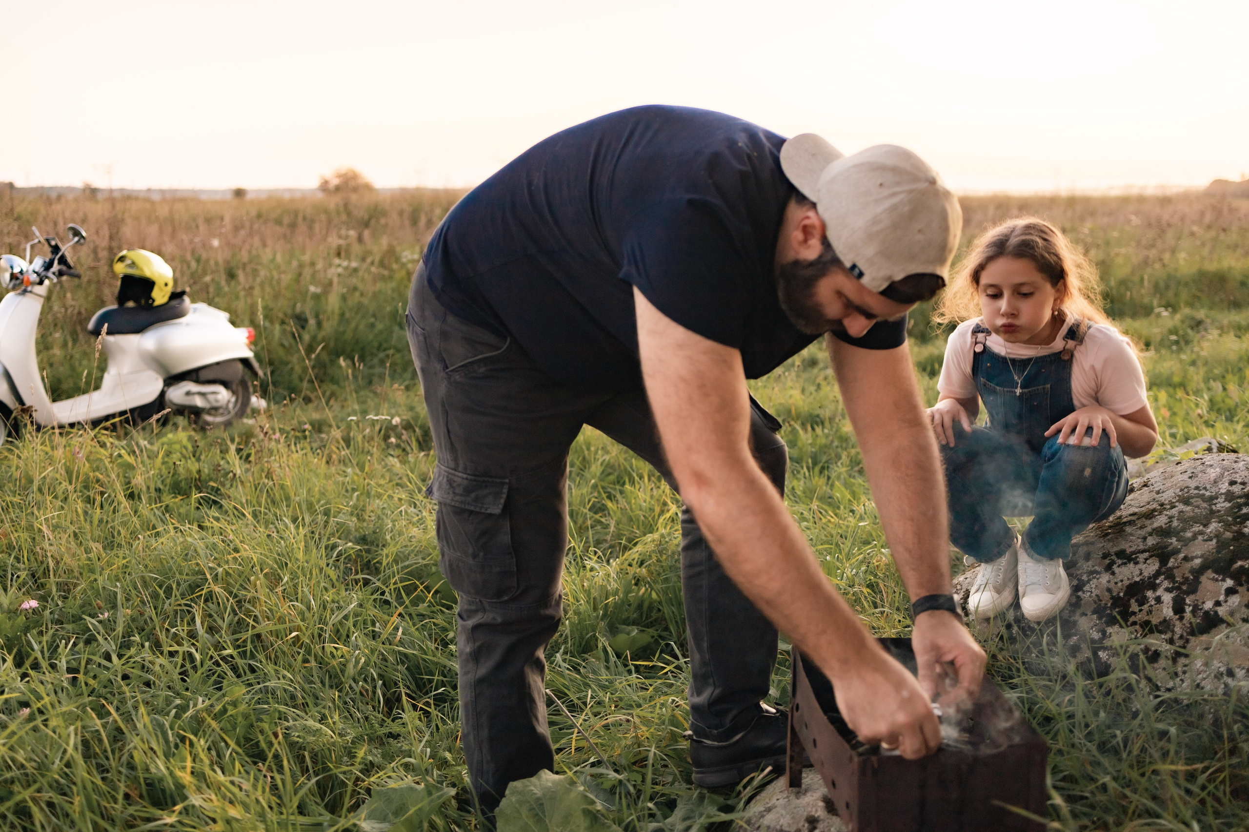 Совместный кулинарный опыт: отец и дочь занимаются приготовлением вкуснейших сосисок на открытом огне