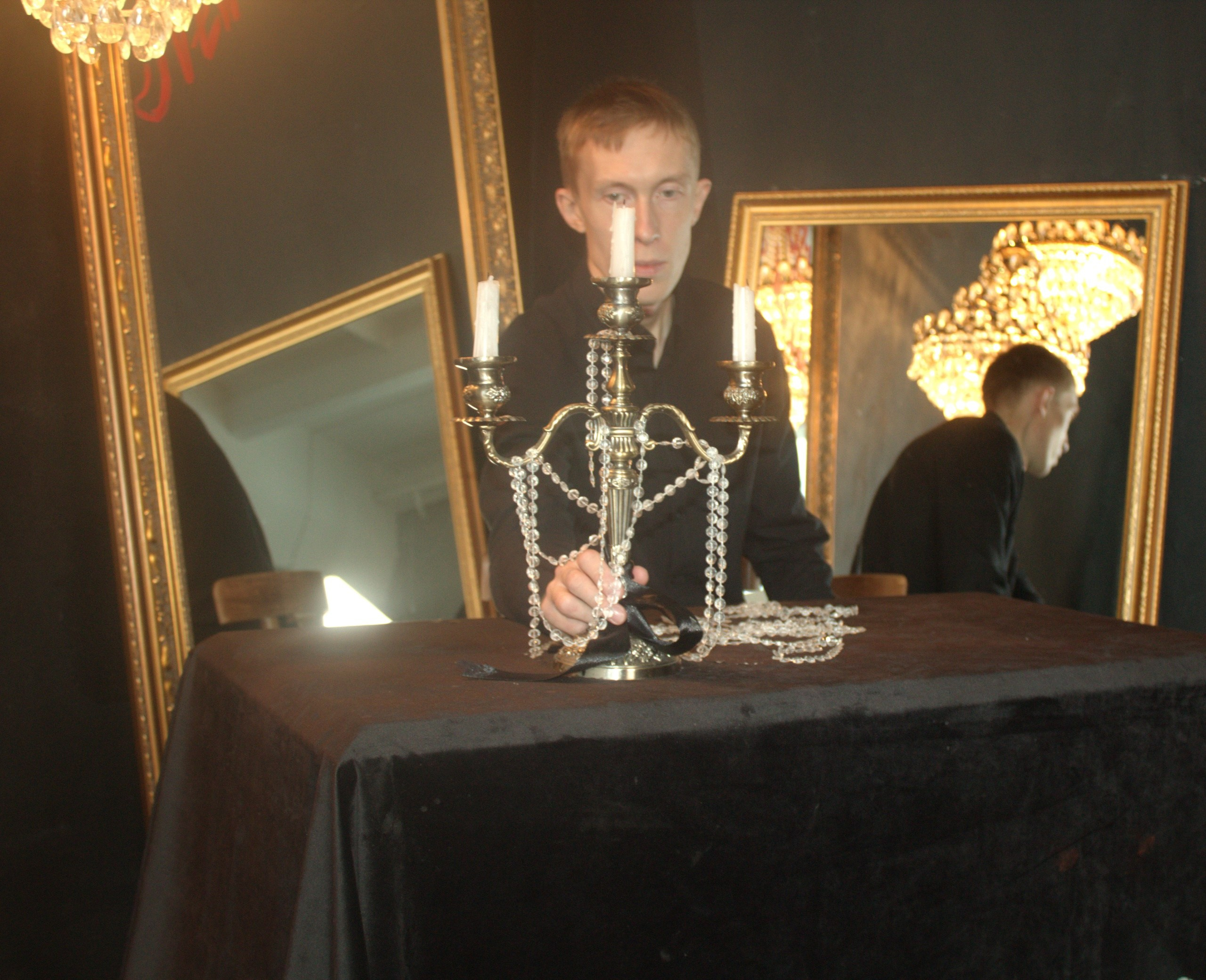 мужчина сидит напротив свечей