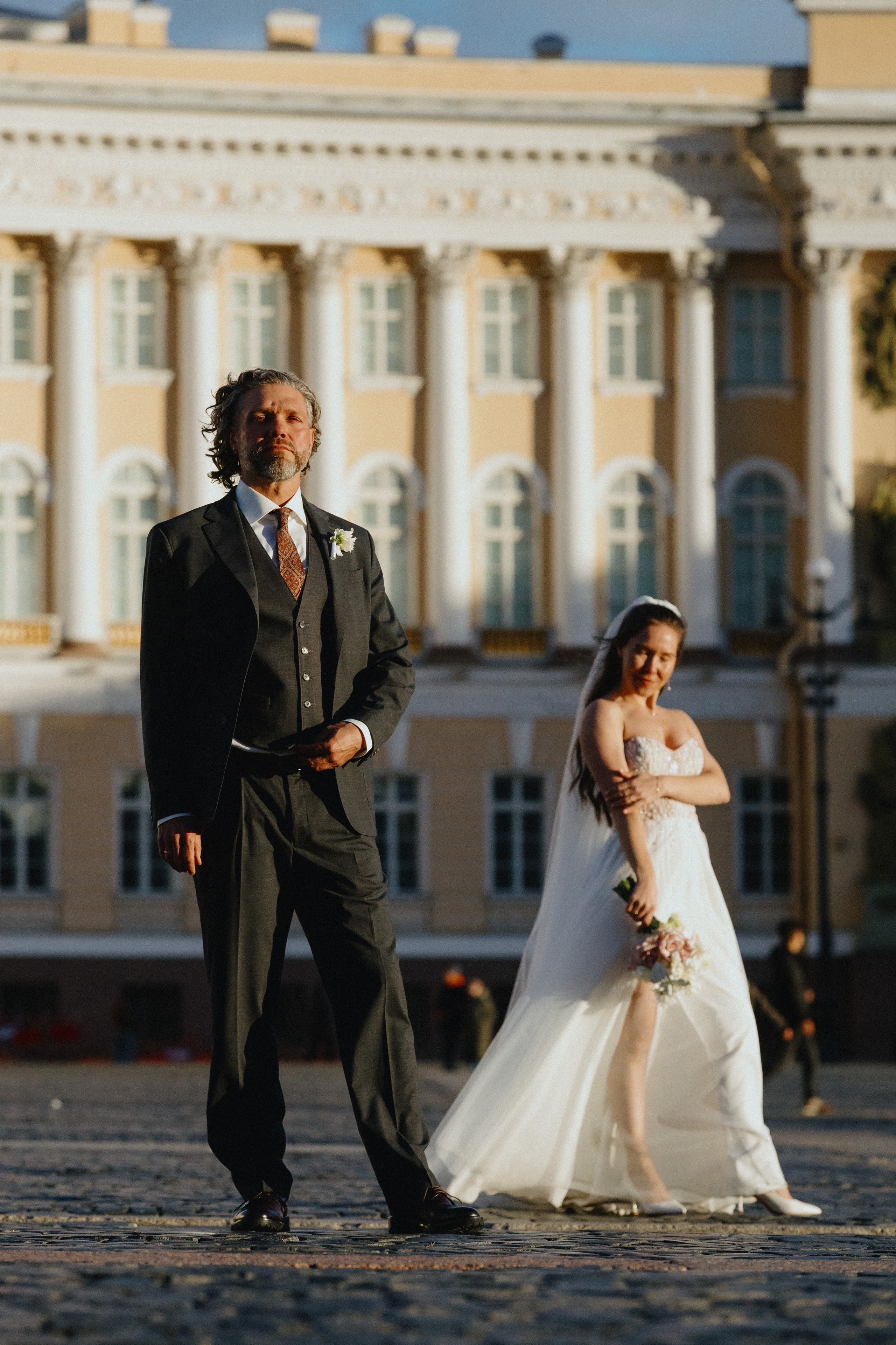 Свадебная фотосессия на Дворцовой площади: жених и невеста позируют на фоне Зимнего дворца. Классическая свадебная съемка.