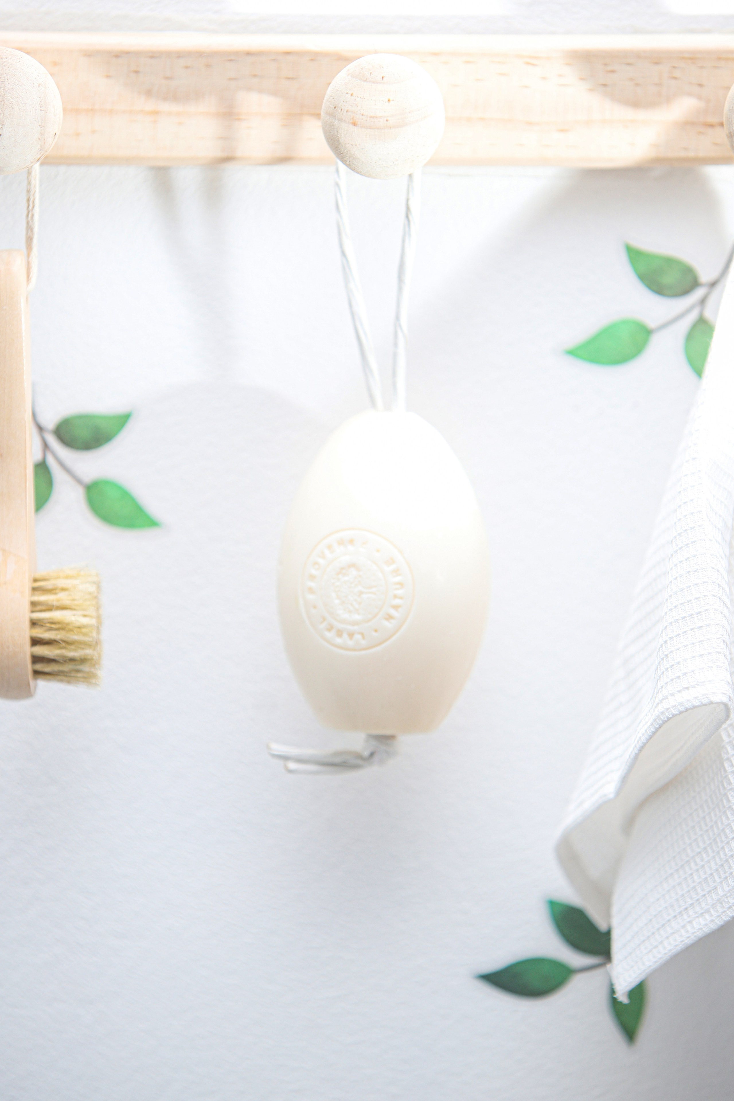 Рекламное фото белого овального мыла с верёвочкой — каталожная съёмка.