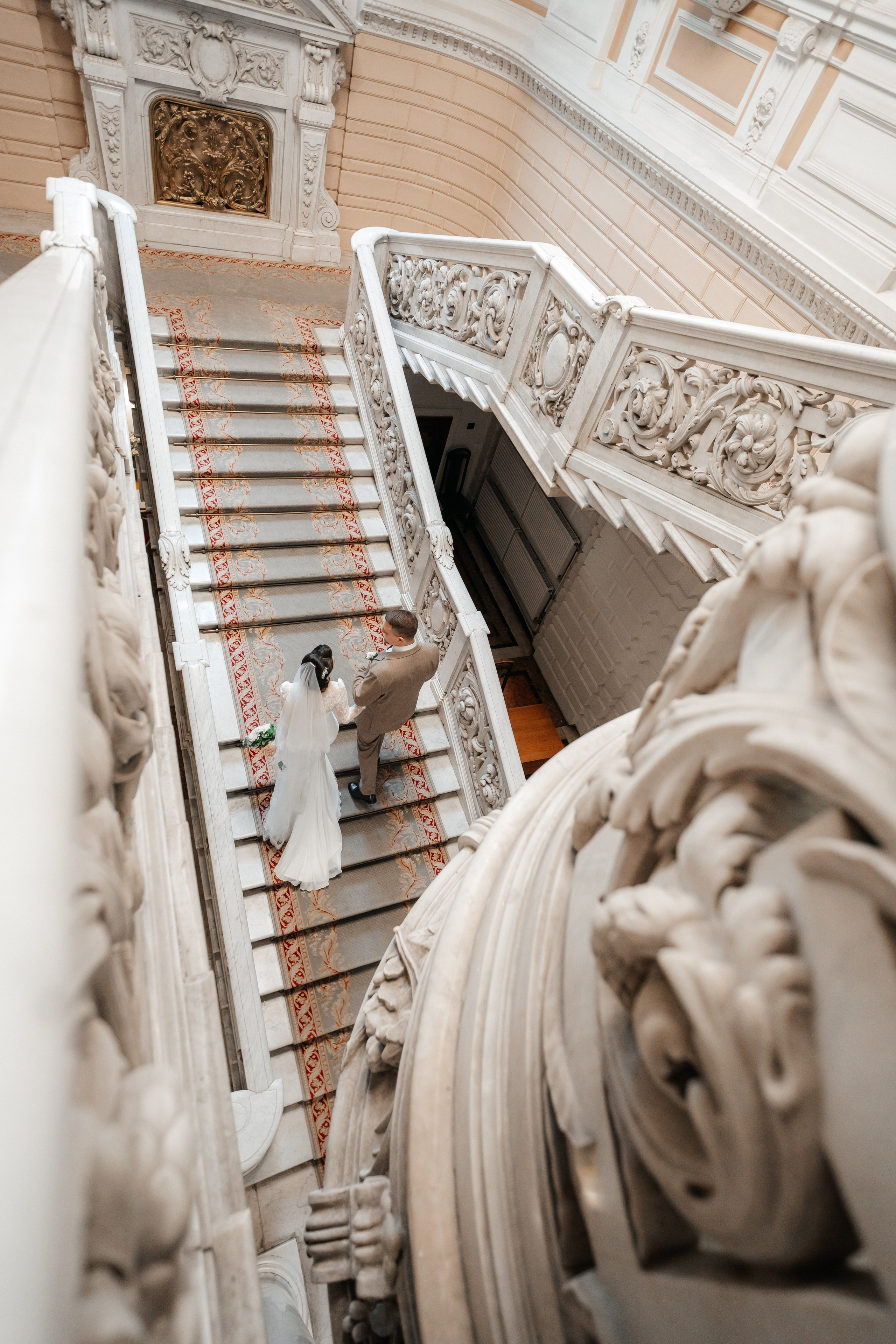 Свадебная фотосессия во Дворце Бракосочетания №1 молодая пара поднимается по лестнице.