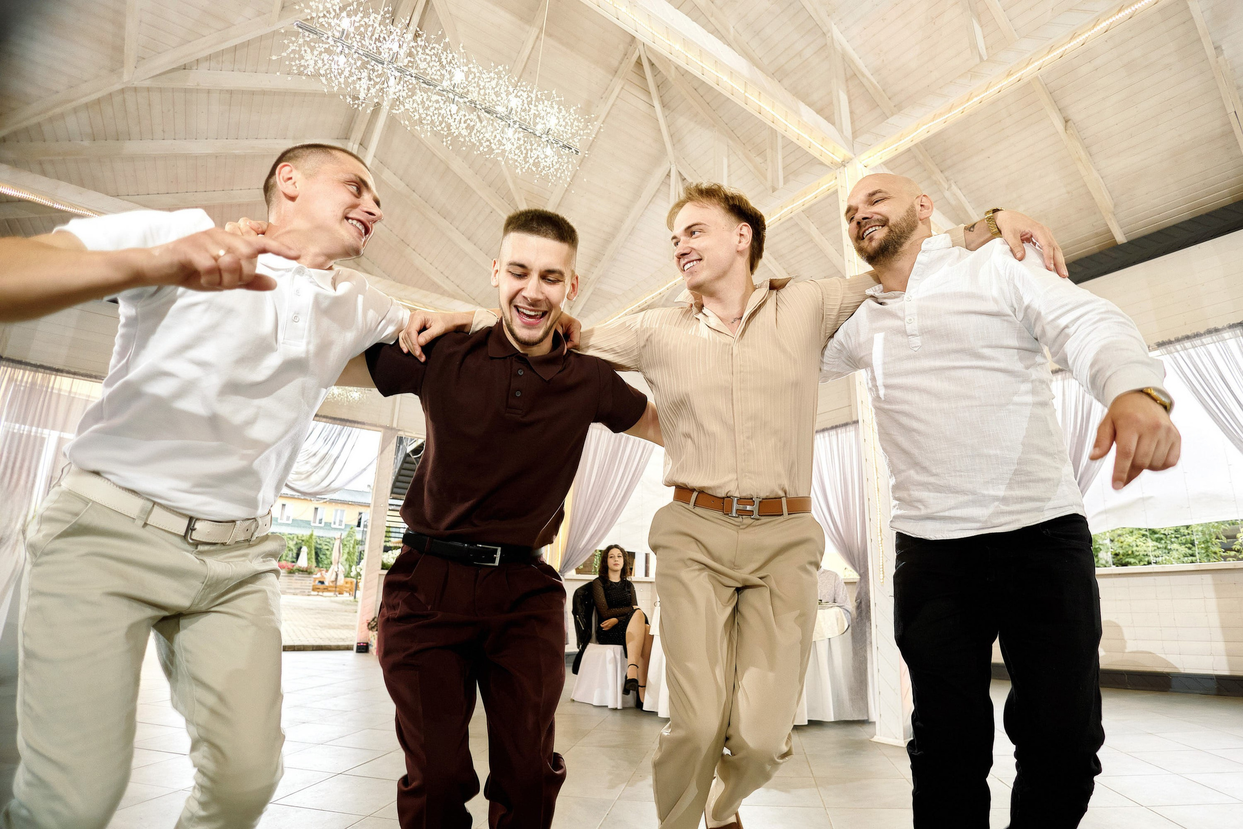 Танец друзей жениха на свадебном банкете в светлом зале