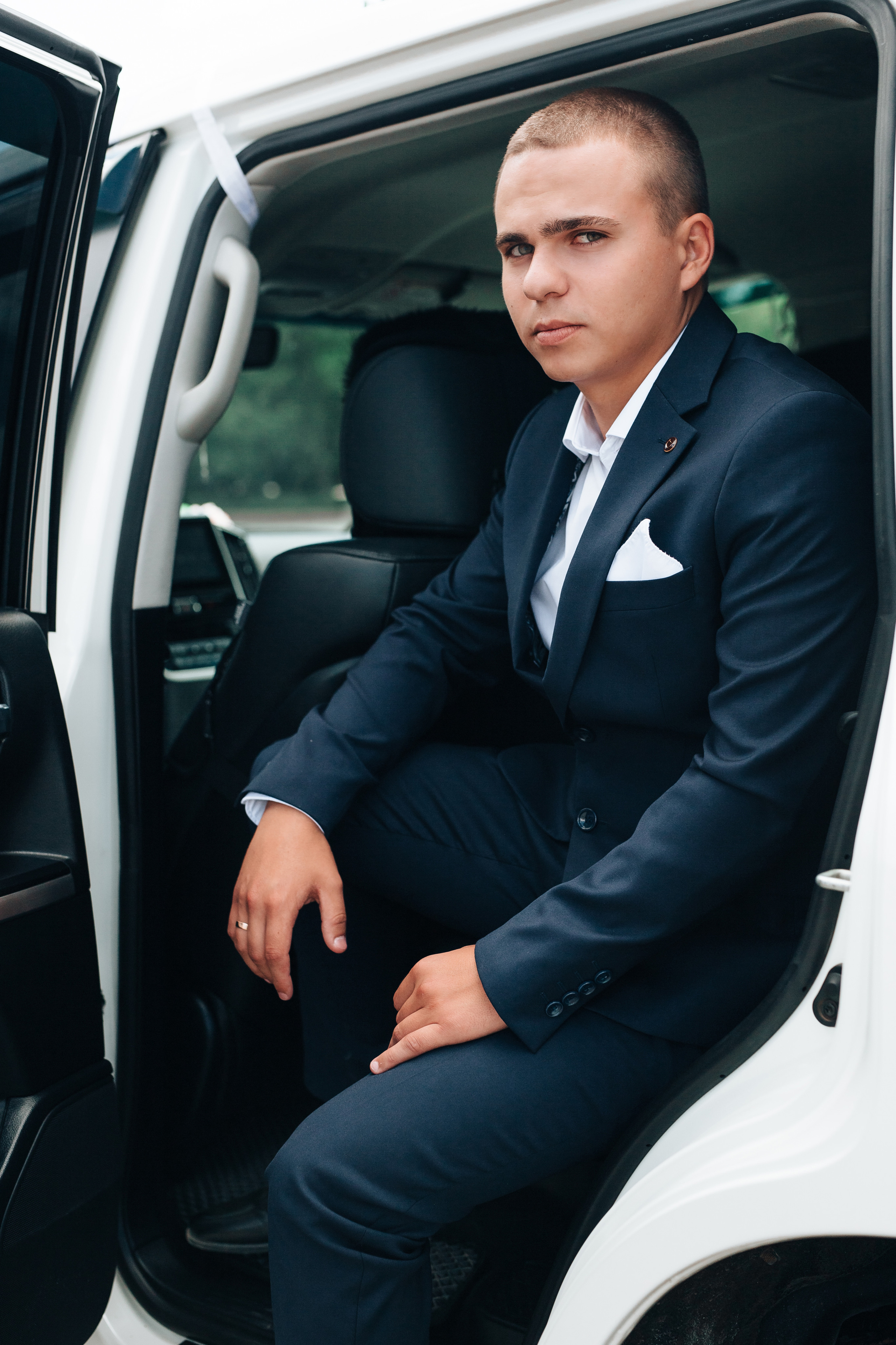 портретная фотография жениха в машине