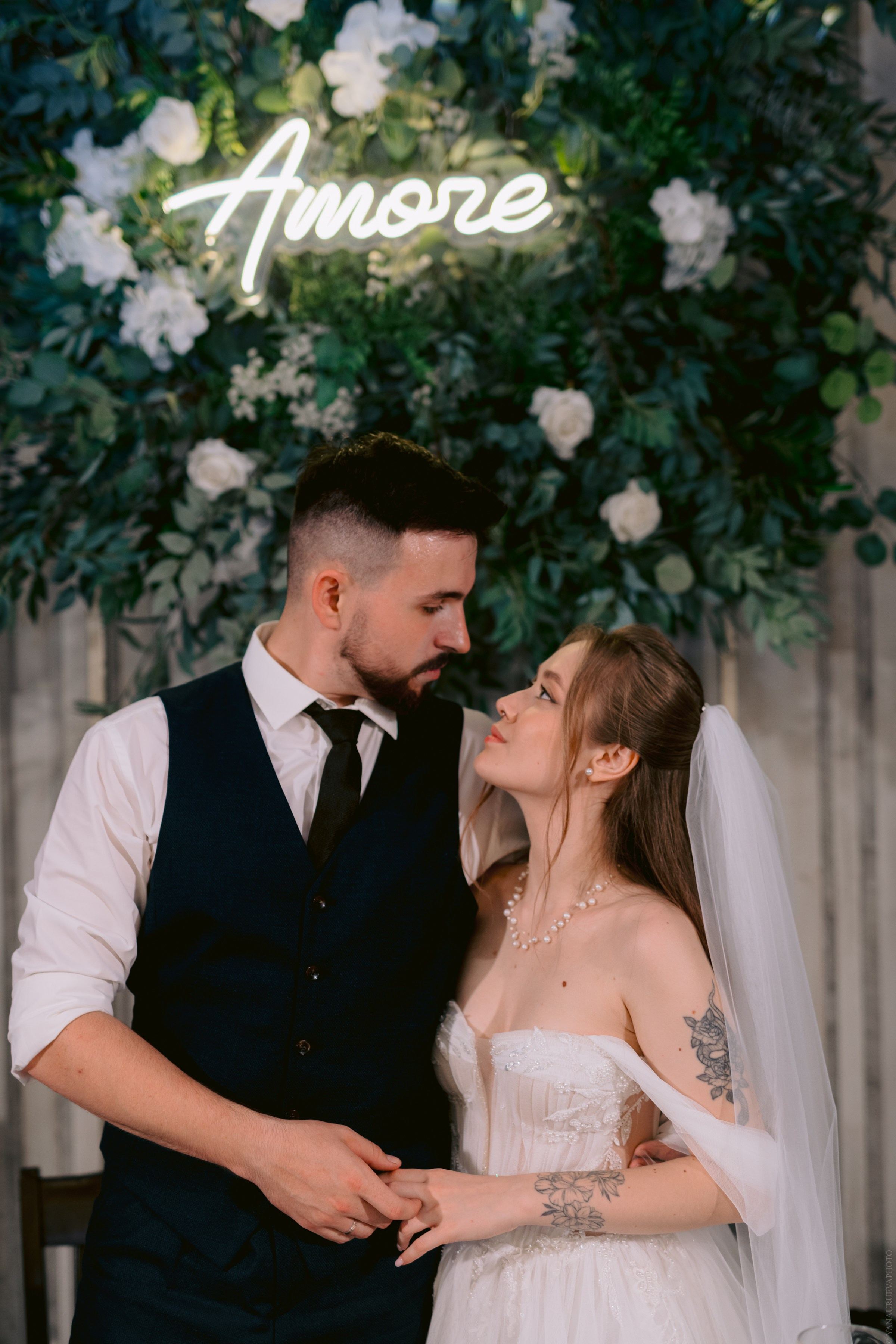 жених смотрит на невесту за столом 