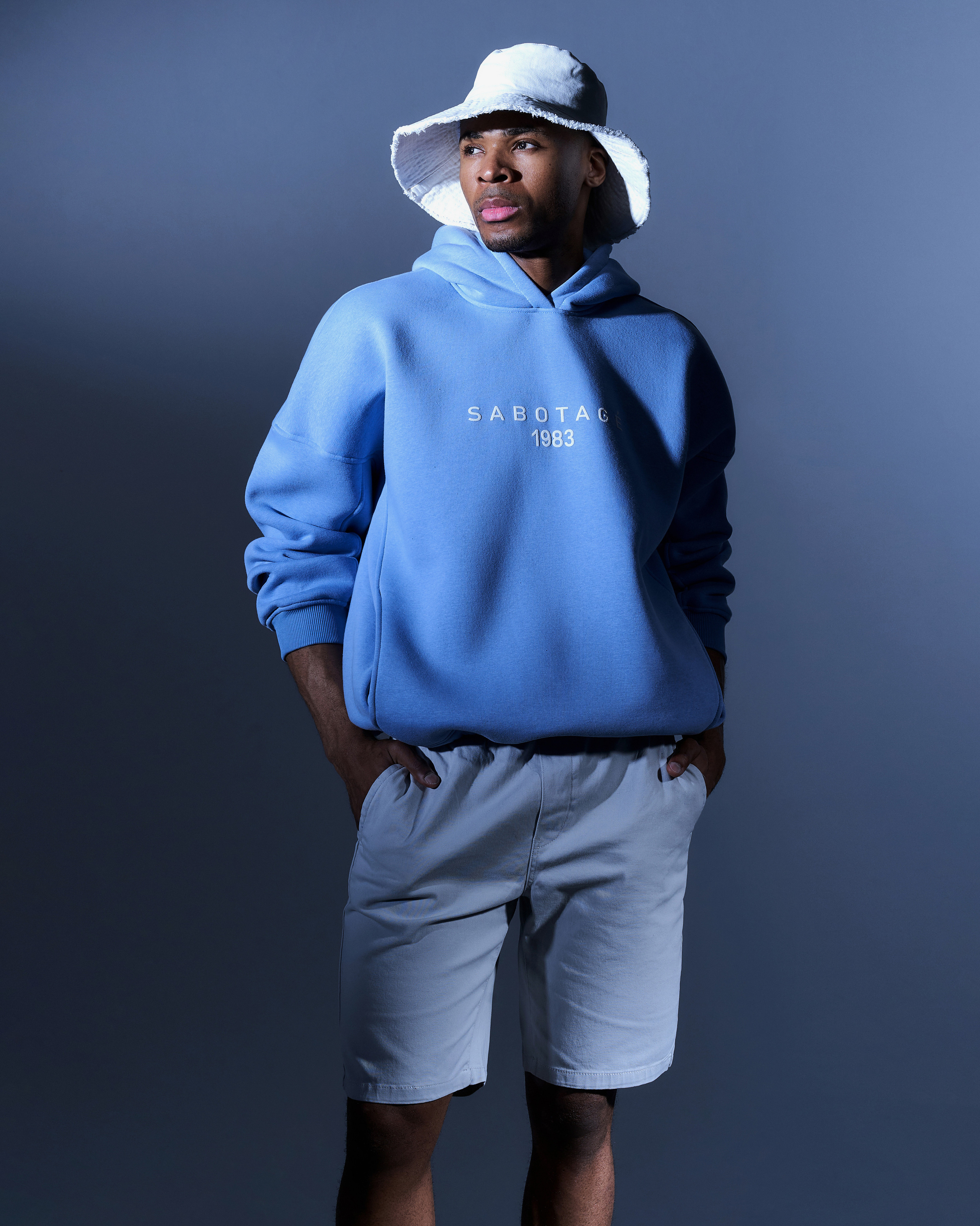 Оверсайз спортивная одежда с жестким акцентным светом. Парень в голубом худи.