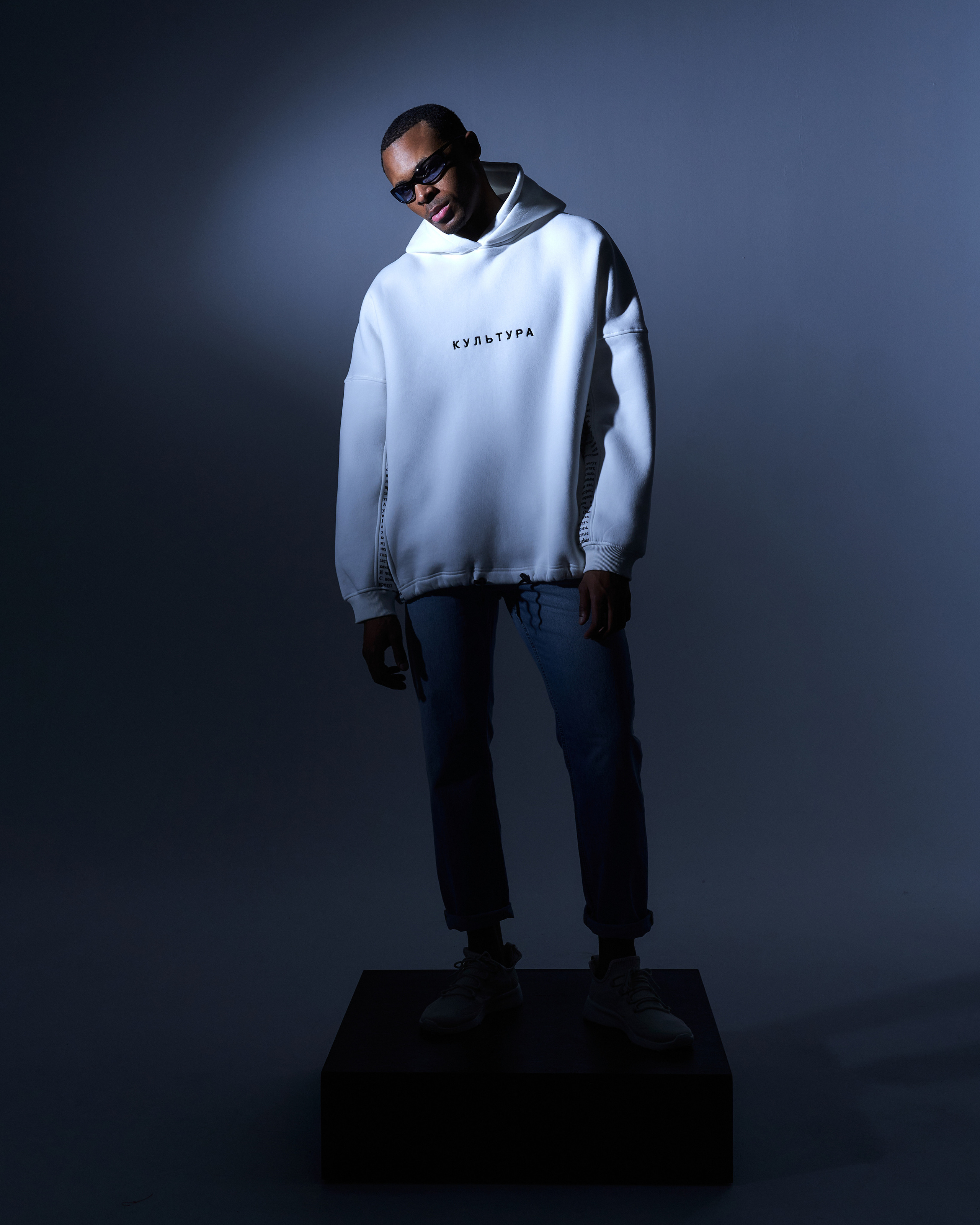 Темнокожий парень модель в фотосессии на циклораме с креативным светом для бренда одежды