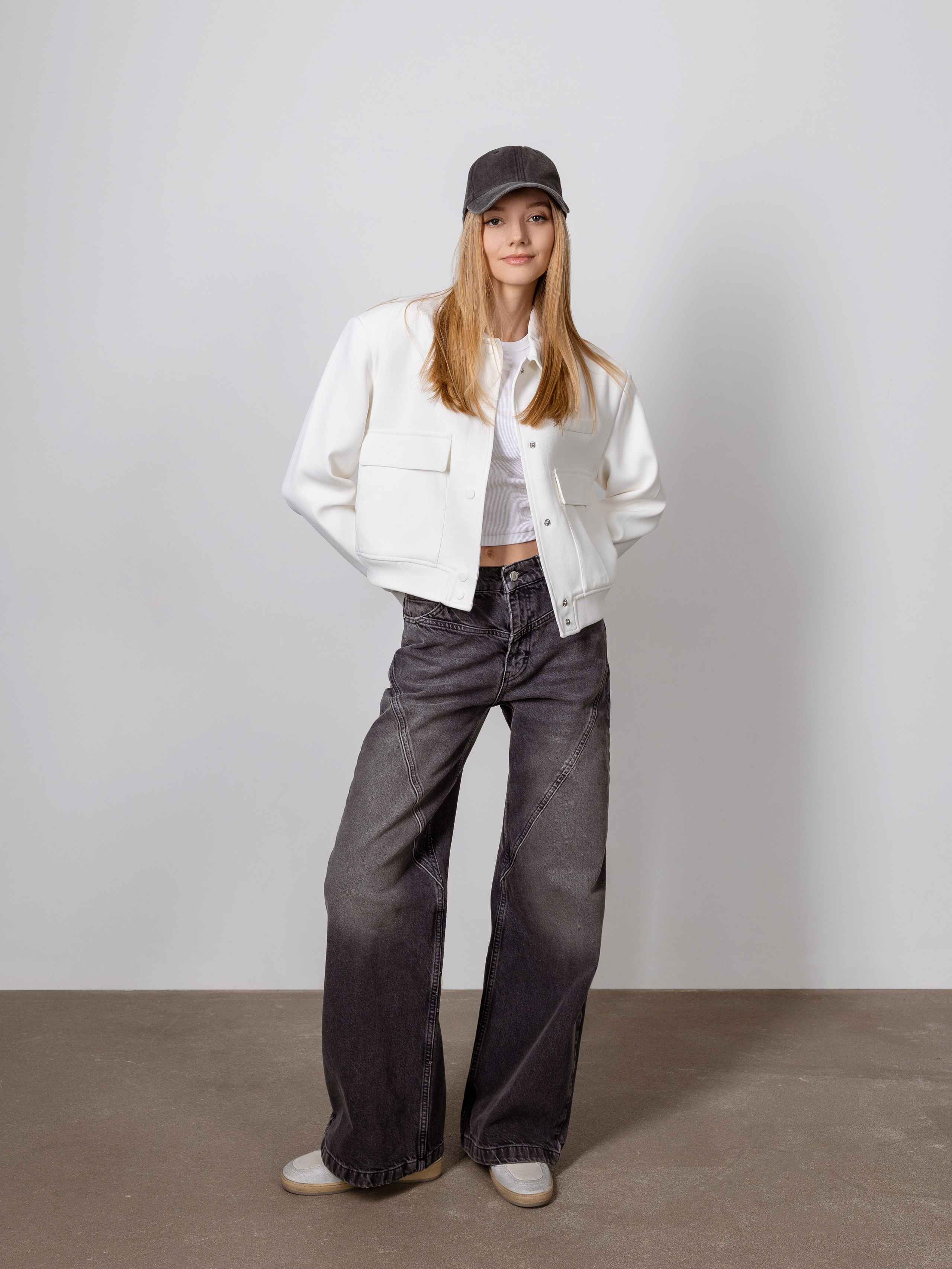 На голубом фоне девушка в черном кепи.