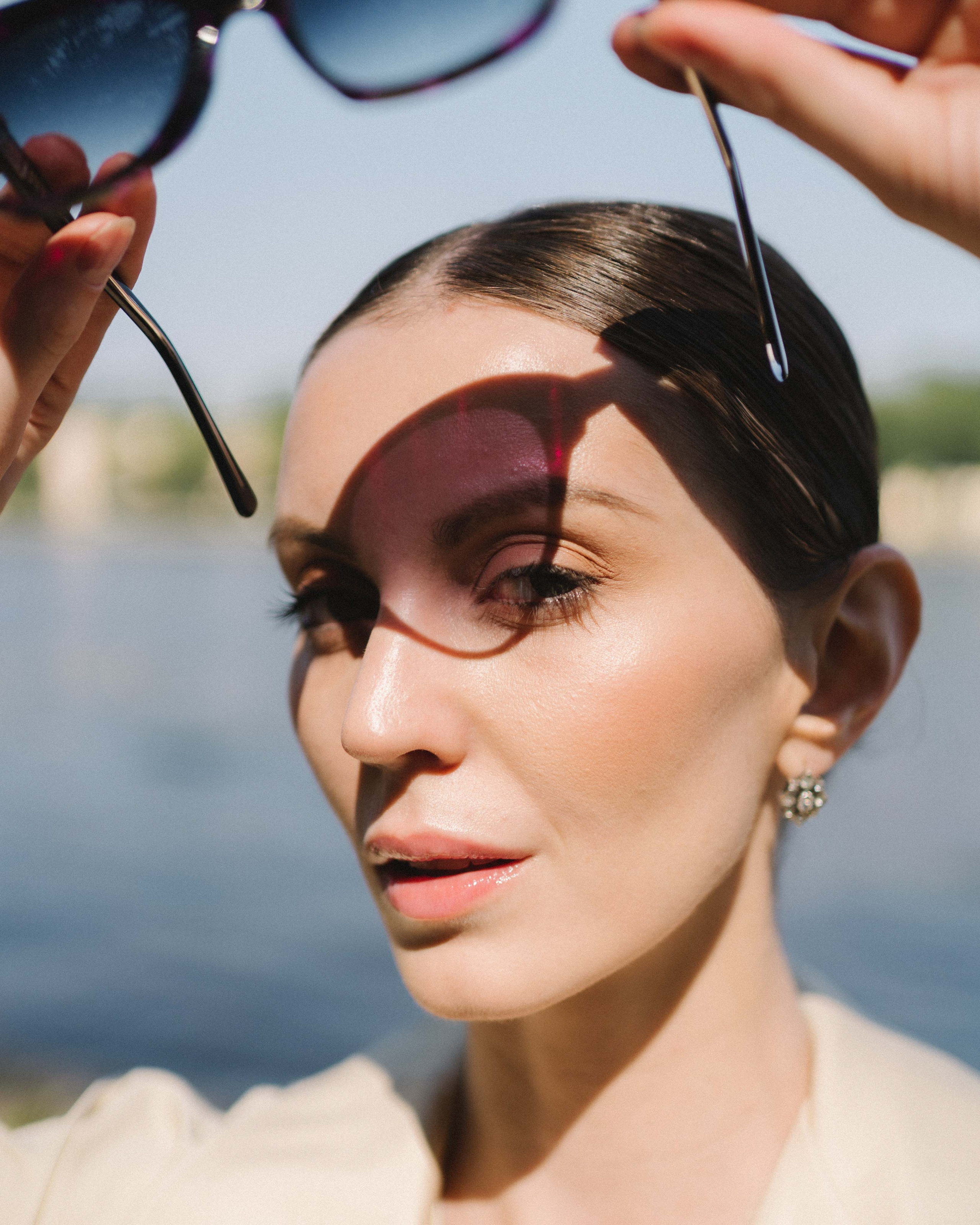 Креативная фотография модели в парке с тенью от очков