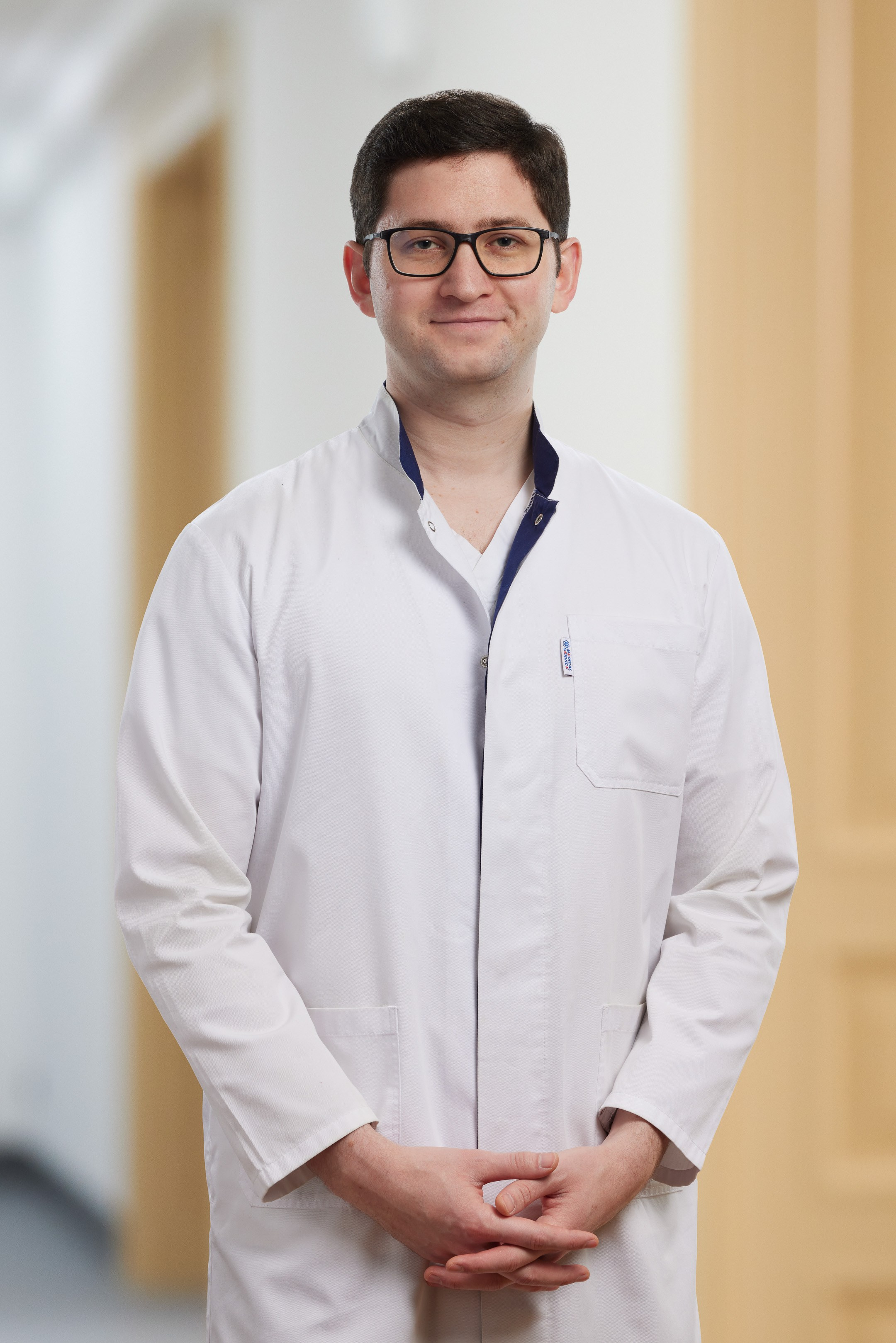 Business portrait of a young doctor against a blurred interior background - photographer Andrey Dunin