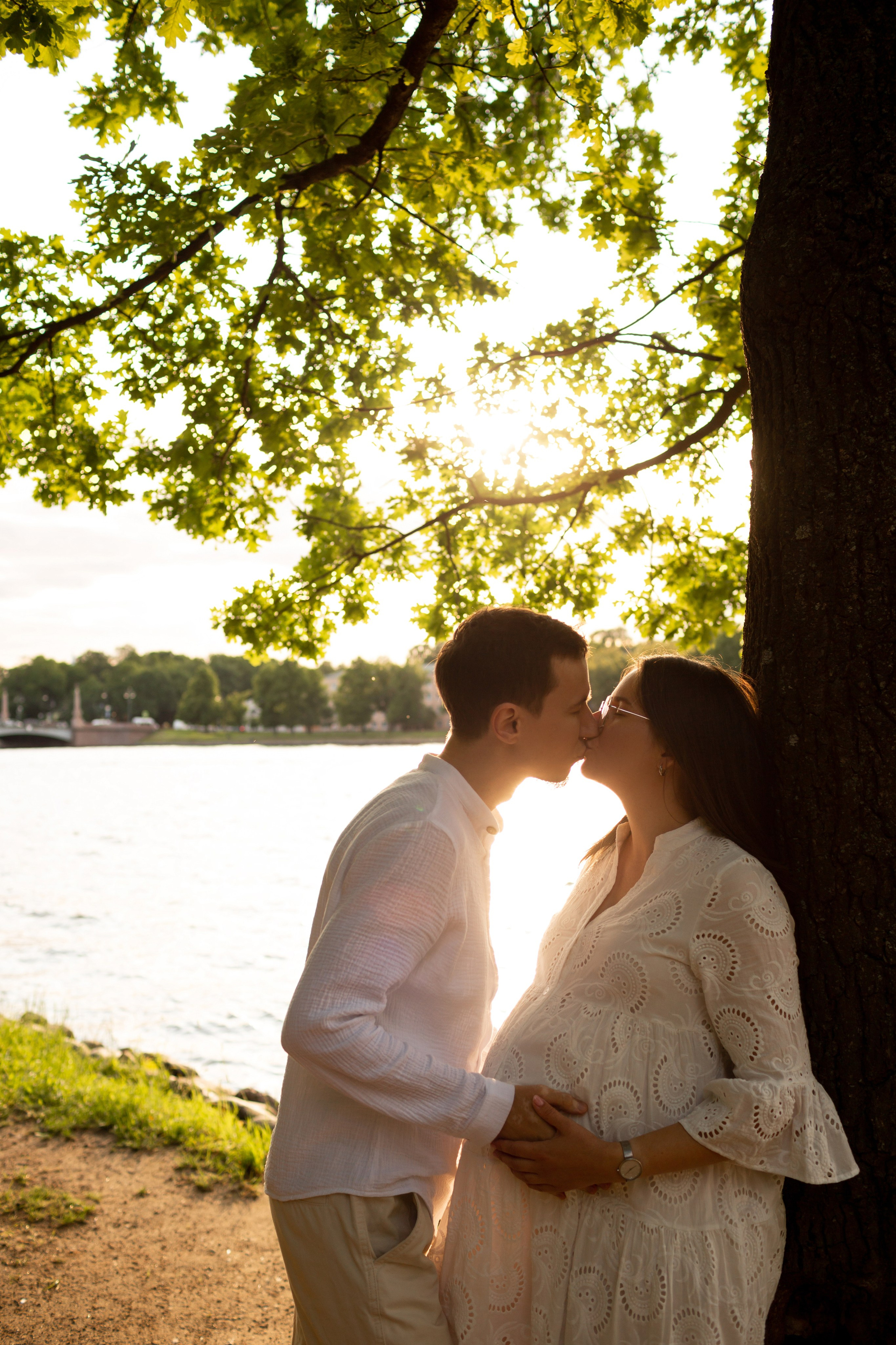 Фотосессия будущих родителей в саду на закате.