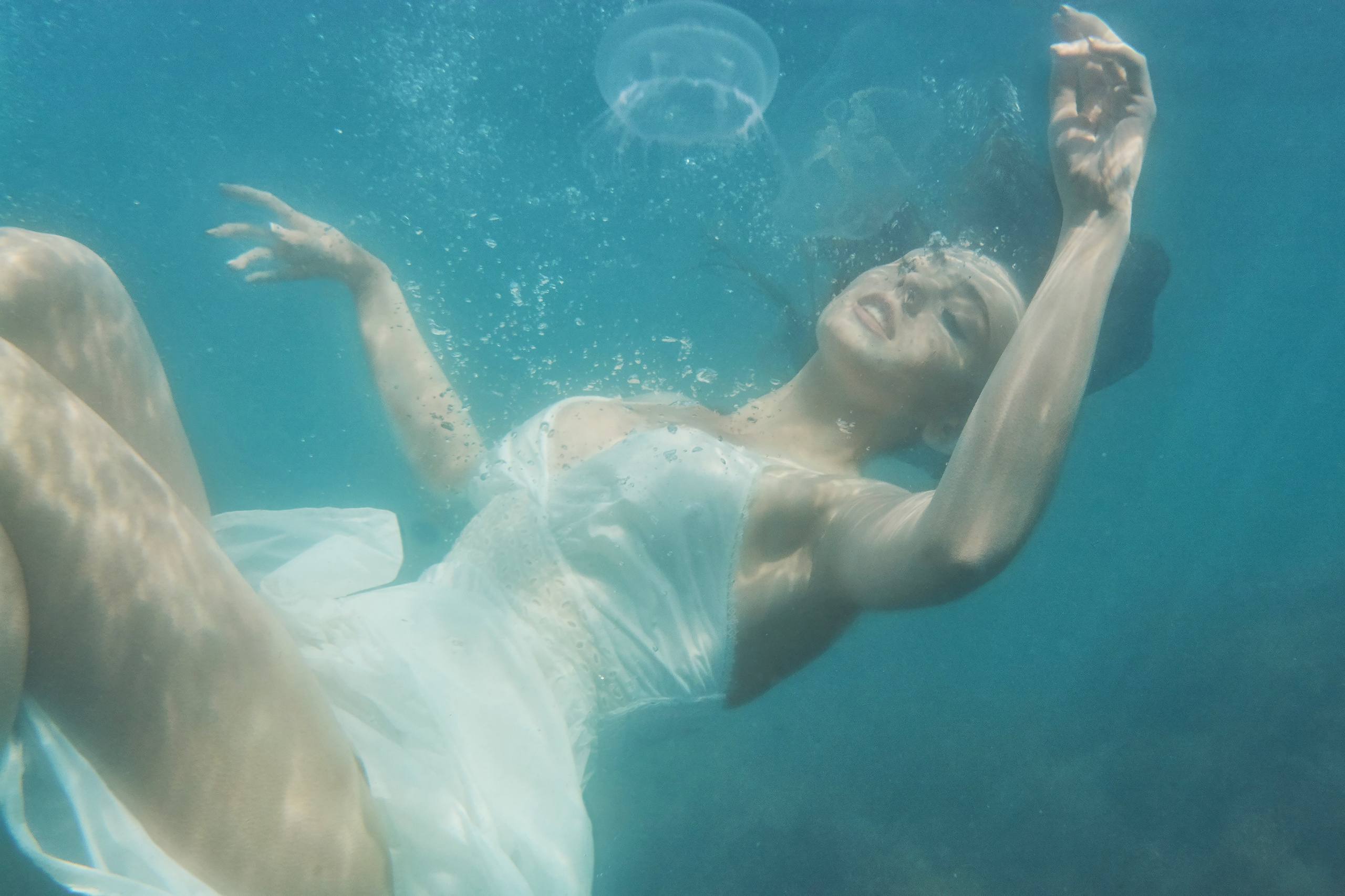 Девушка в белом платье под водой