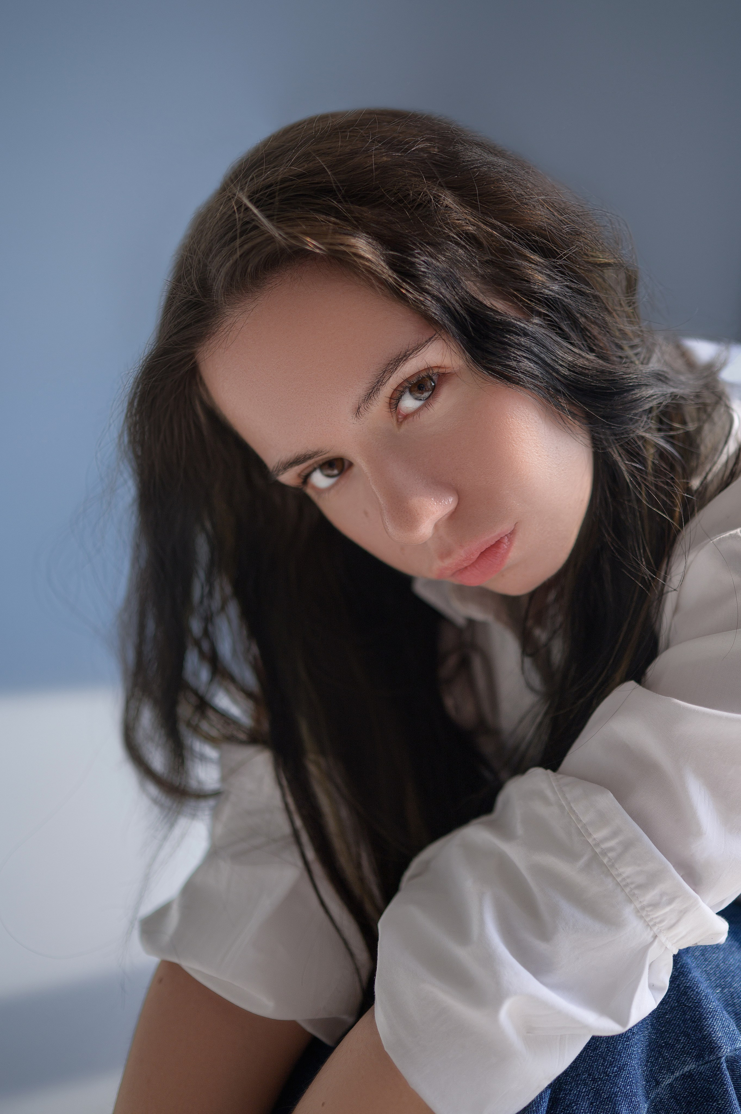 Девушка в рубашке и джинсах на циклораме — фотосессия в студии Rassvet. Игра света и тени, минималистичный фон. Волгодонск.