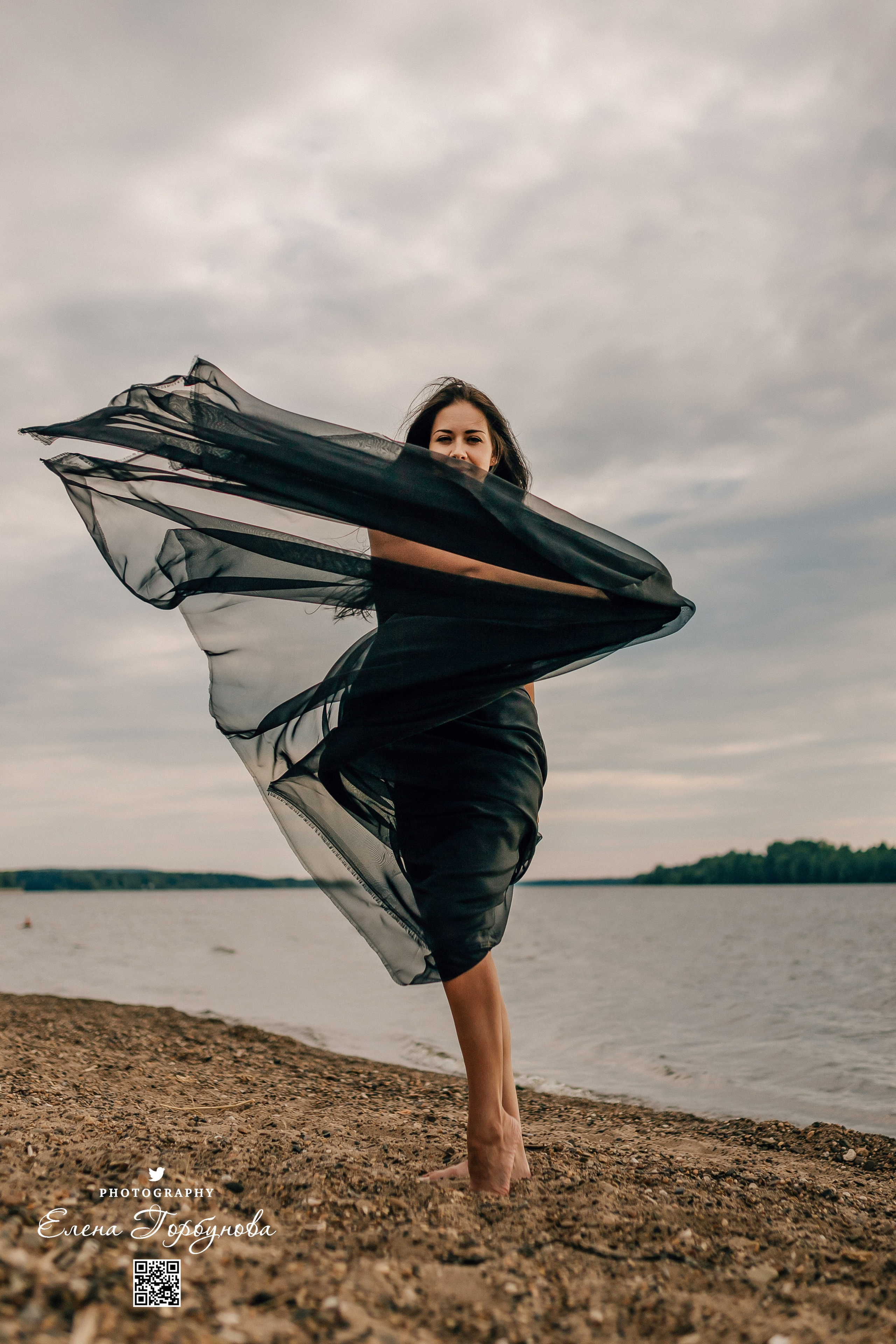 Фотосессия с черной тканью. Легкая черная вуаль летит на вертру. Фотосессия у реки черная серия с тканью. Девушка укуталась в черную ткань. Прогулка по набережной. Песок, речка, модель в черном. Качели над водой, Закат. Девушка лежит на песке. В зеленых деревьях