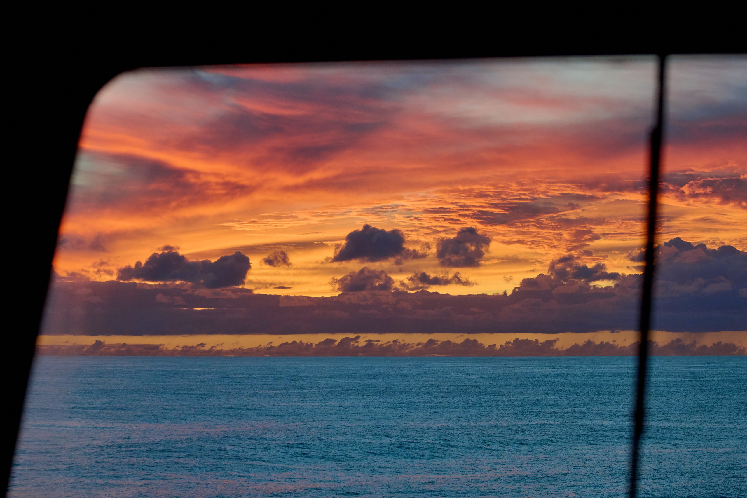 закат в море через лобовой иллюминатор судна