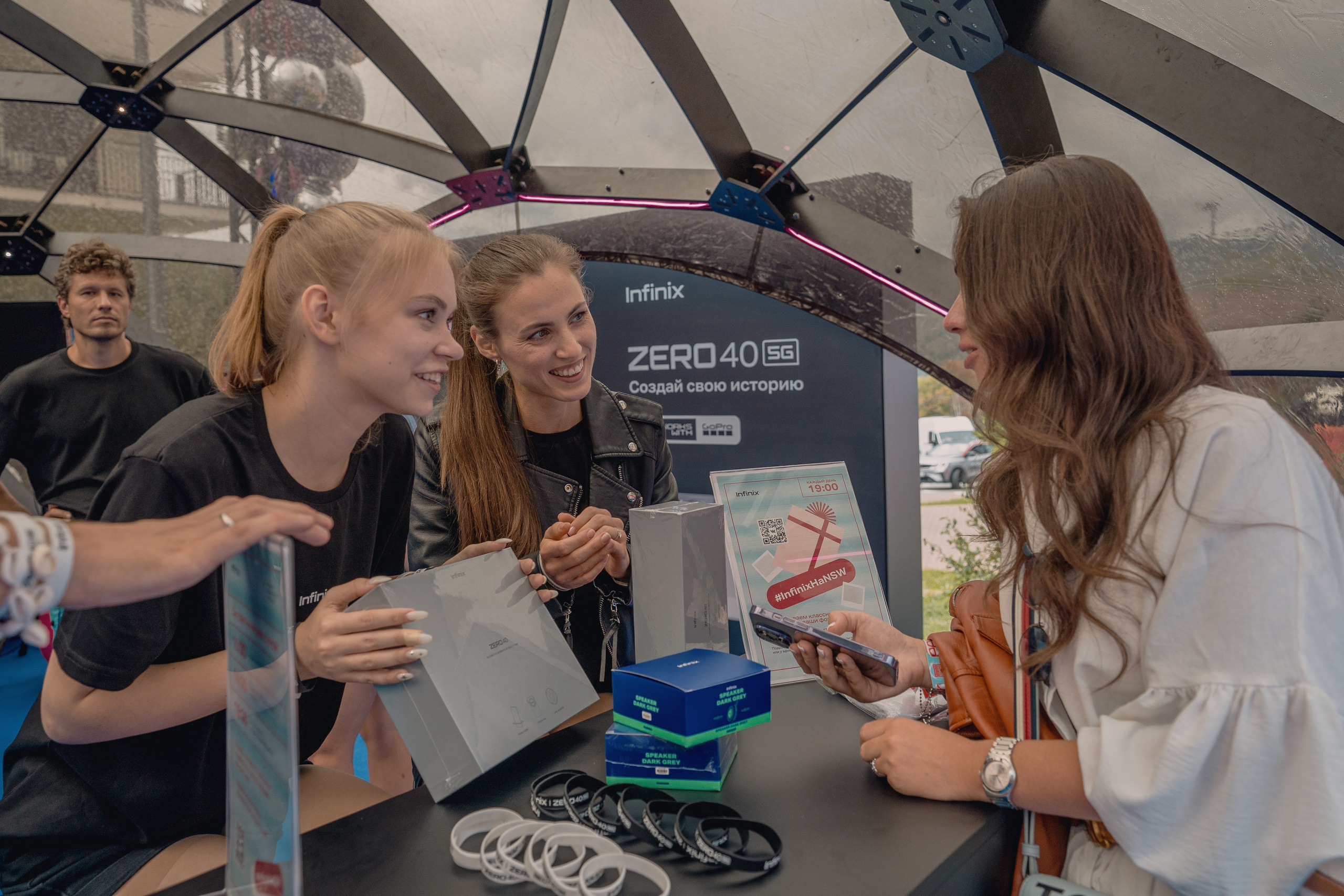 Фотография с промо стойки: девушки объясняют условия