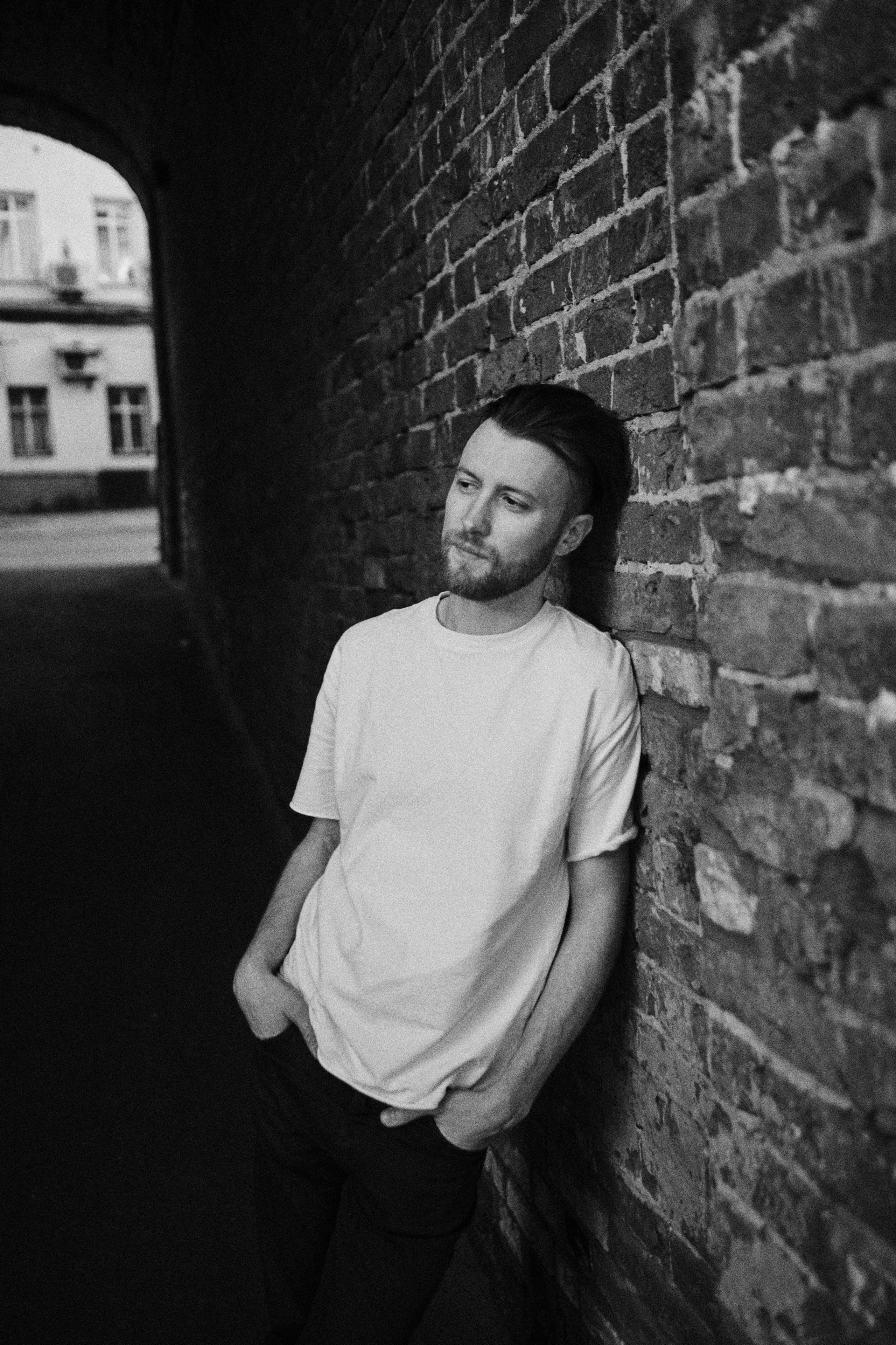 Мужчина в старом кирпичной арке смотрит в сторону