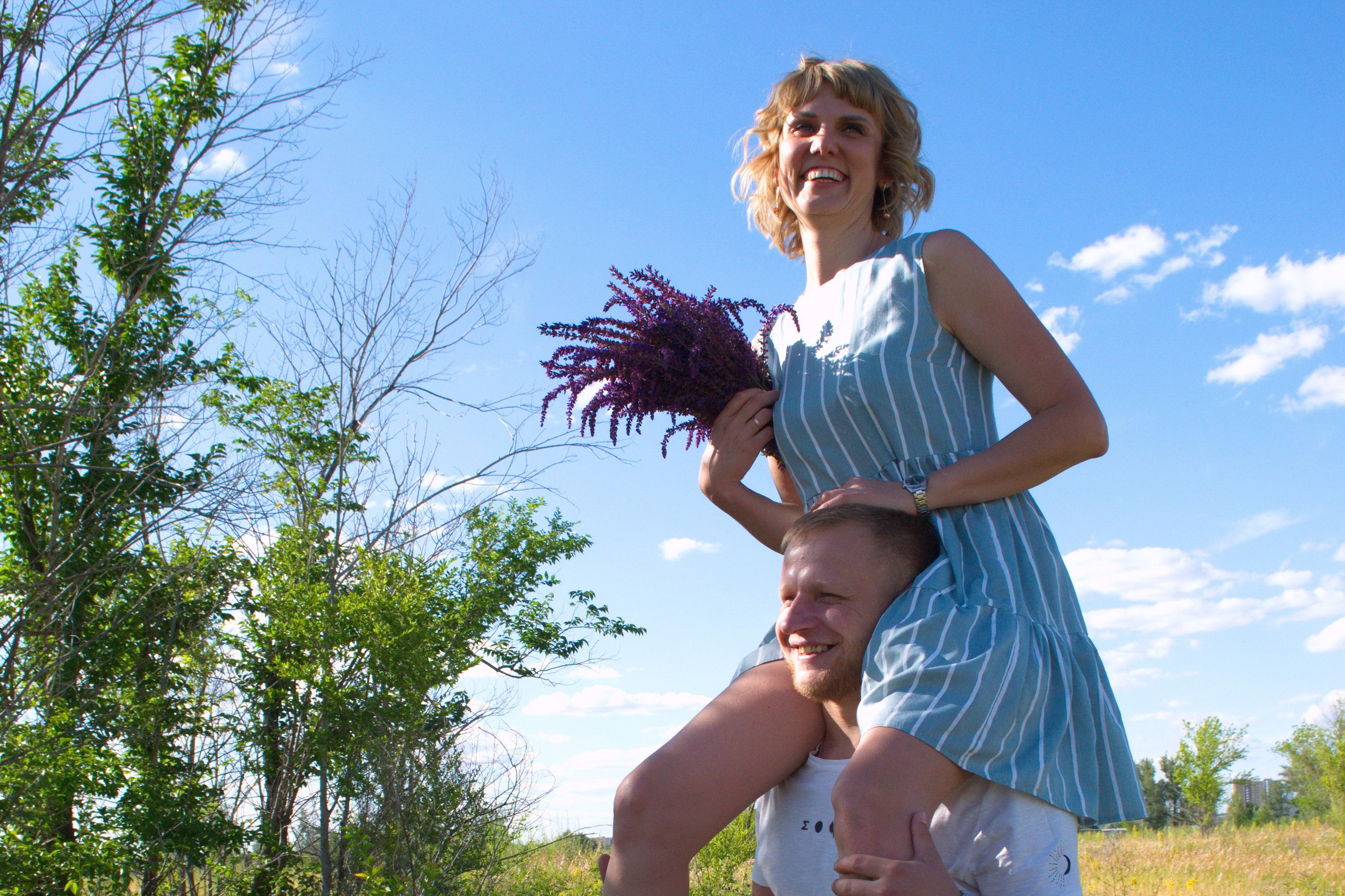 Жена сидит на плечах мужа. Весёлая фотосессия.