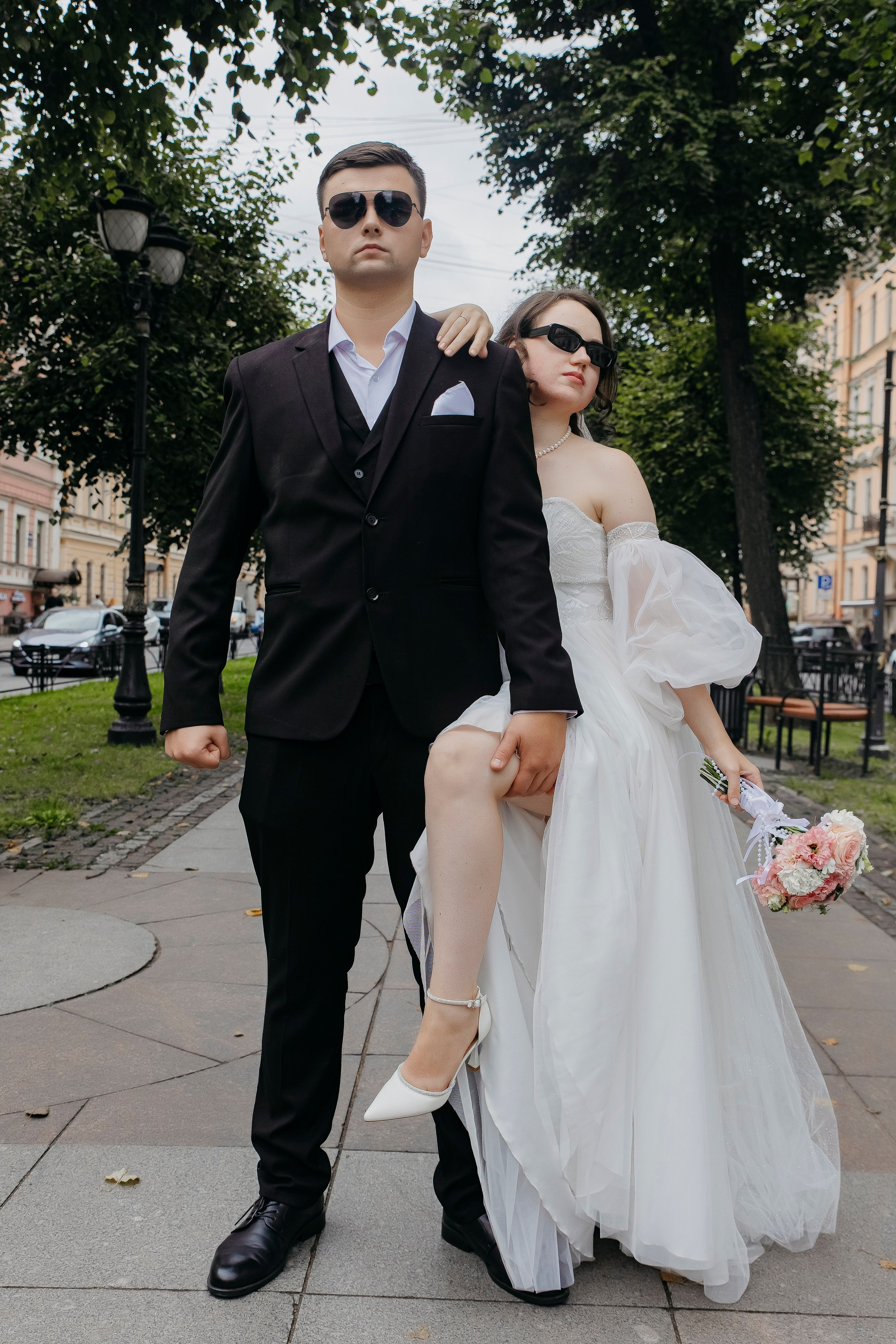 Молодожёны на прогулке с букетом