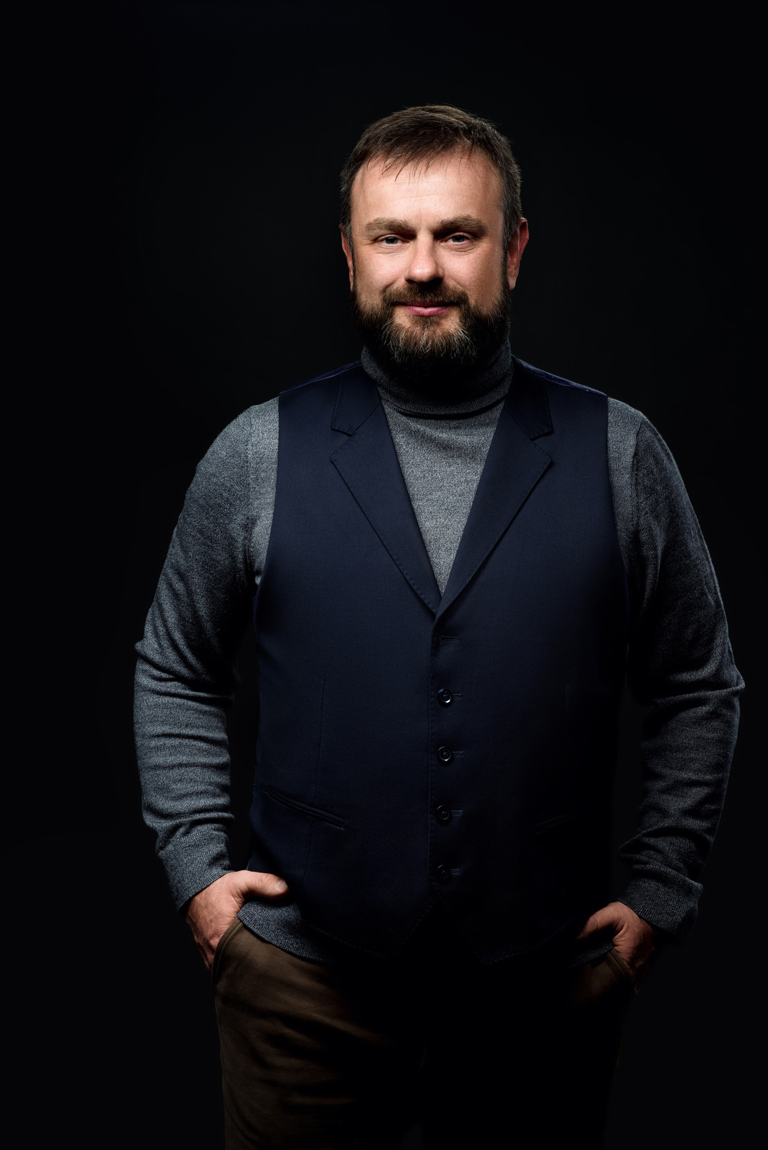 Деловой портрет мужчины с бородой в жилетке в студии