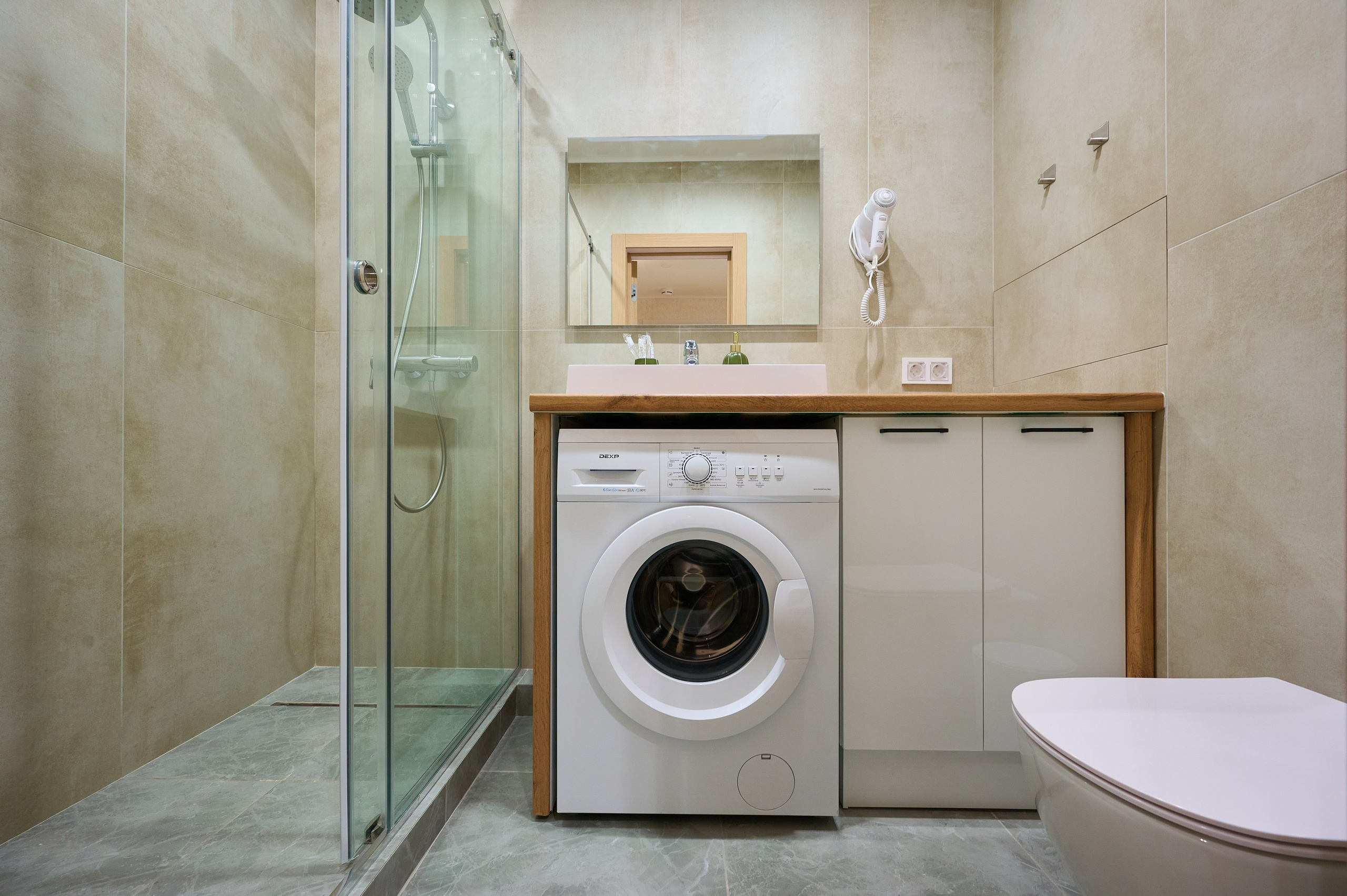 ванная комната светлые плиты душевая кабина белые ящики белая раковина зеркало 