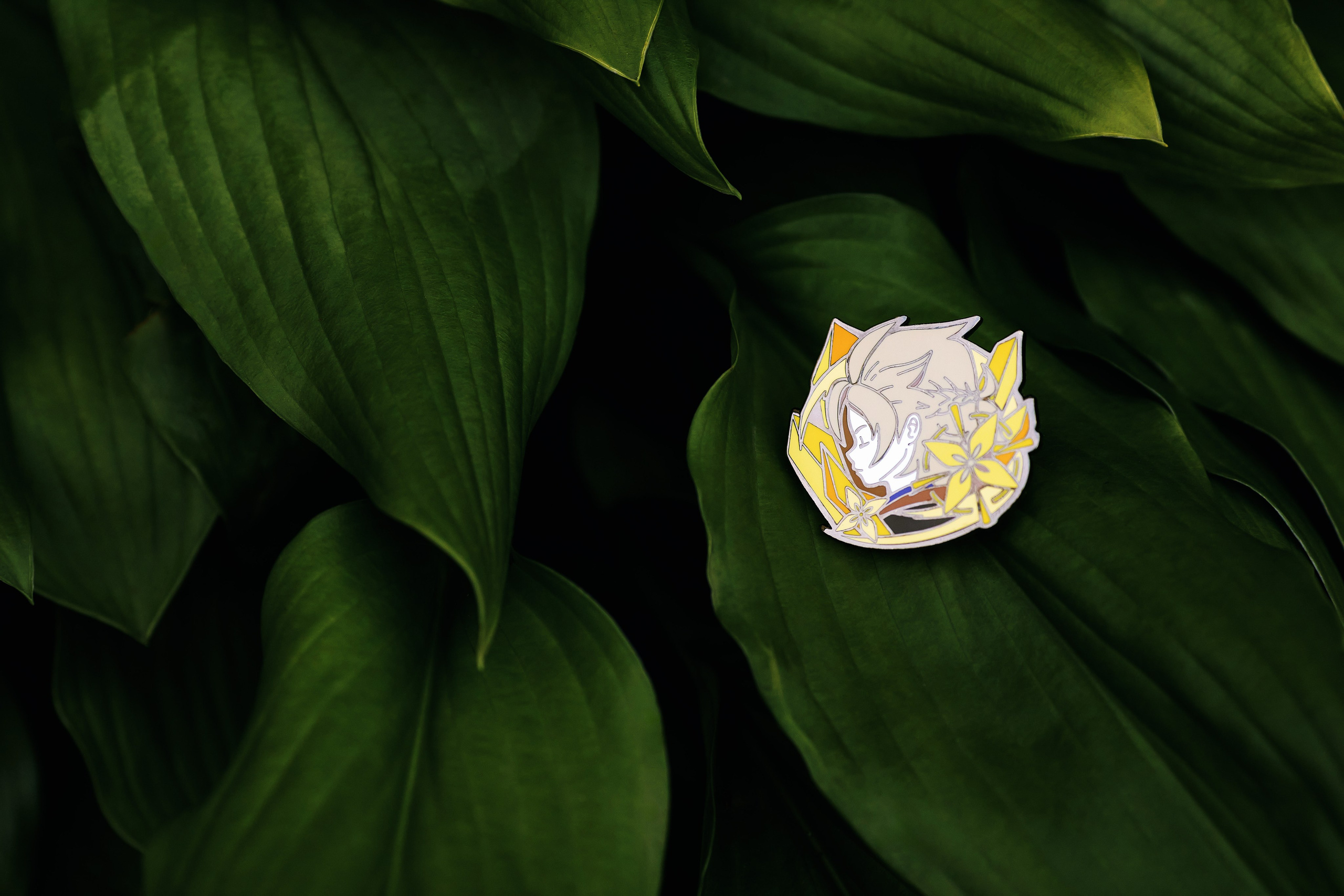 Пин с персонажем Альбедо из игры Genshin Impact - фото на крупных зелёных листьях